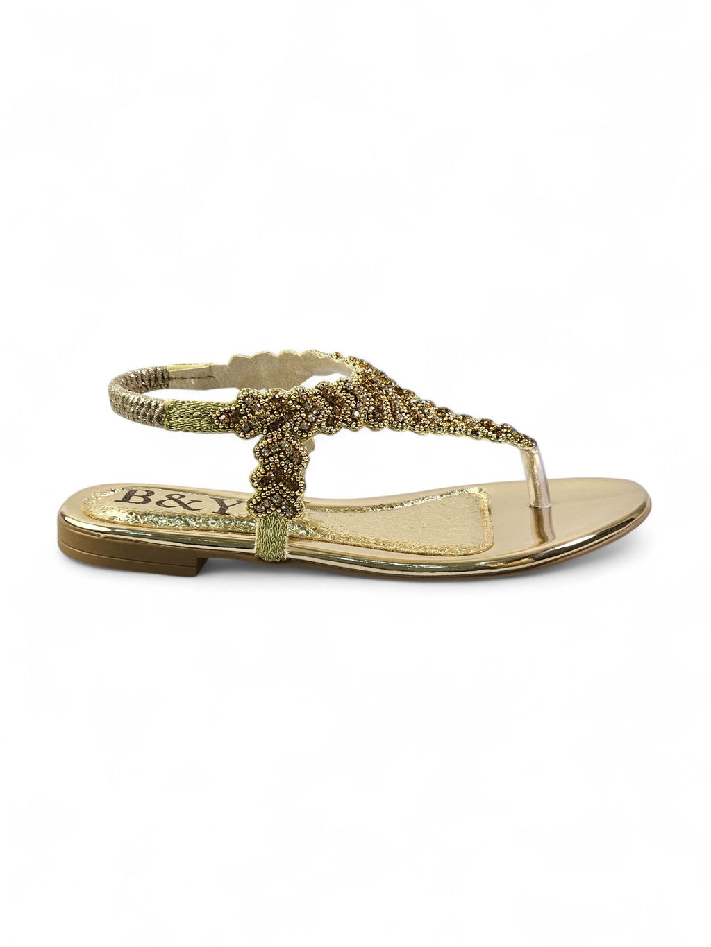 A gold-colored sandal with a decorative beaded strap.