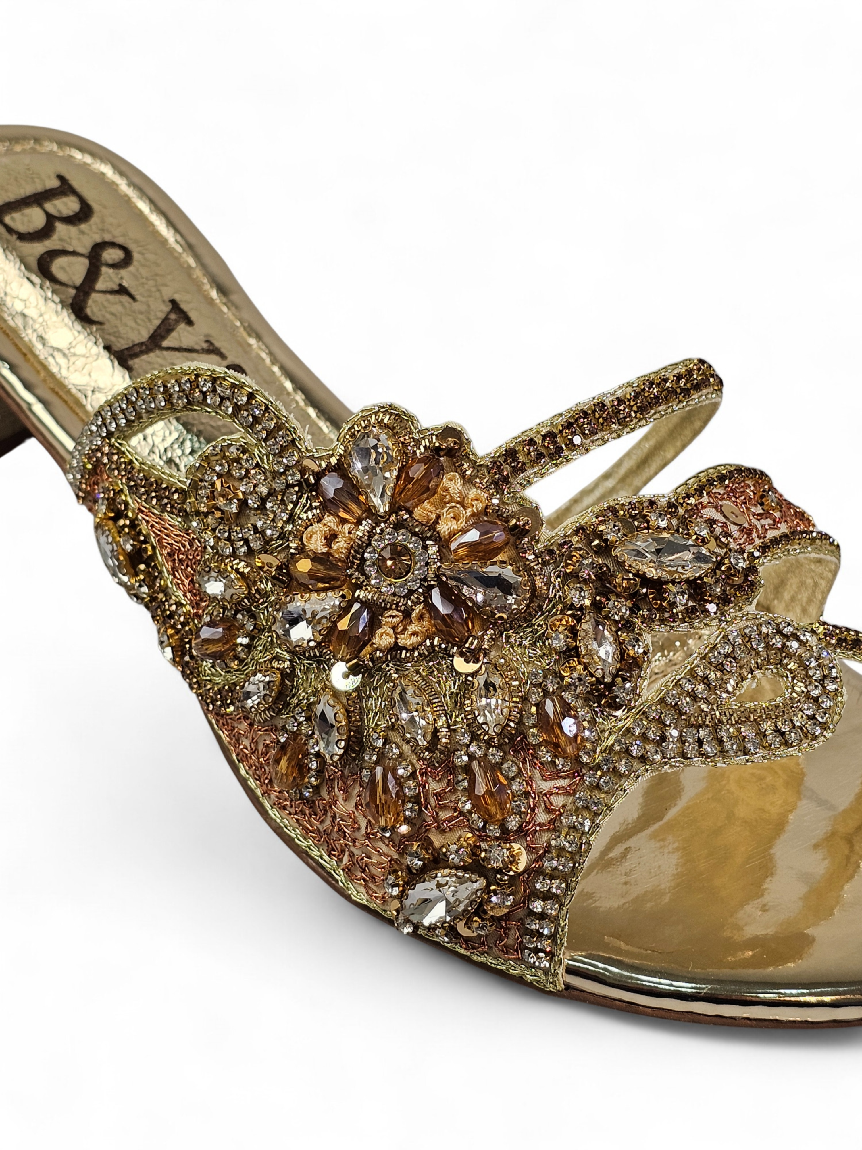 Sandália artesanal dourada com pedrarias florais em tons de dourado, champagne, bronze e prata, feita à mão com salto baixo espelhado.