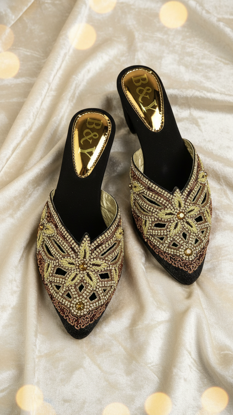 Mule artesanal B&Y preto com bordados manuais em tons dourado, bronze e verde oliva, design floral geométrico, salto médio e acabamento sofisticado.