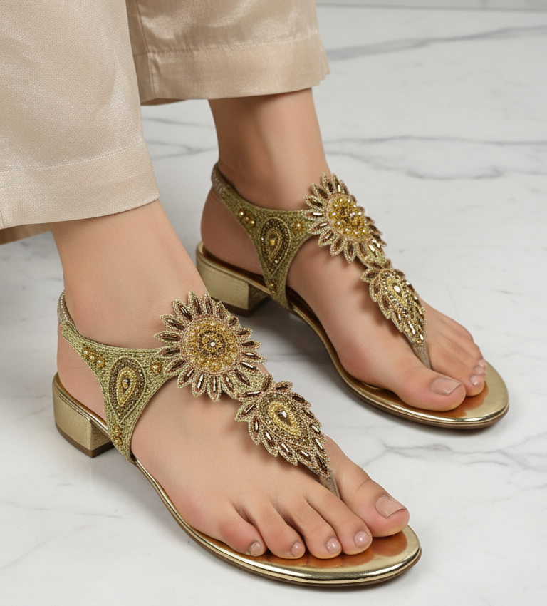 Sandália artesanal dourada com flores bordadas à mão em tons de dourado, âmbar, bronze e pérola, com design em formato de girassol.