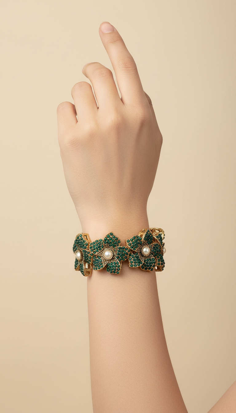 Bracelete floral B&Y com flores verde-esmeralda, detalhes dourados e pérolas no centro.