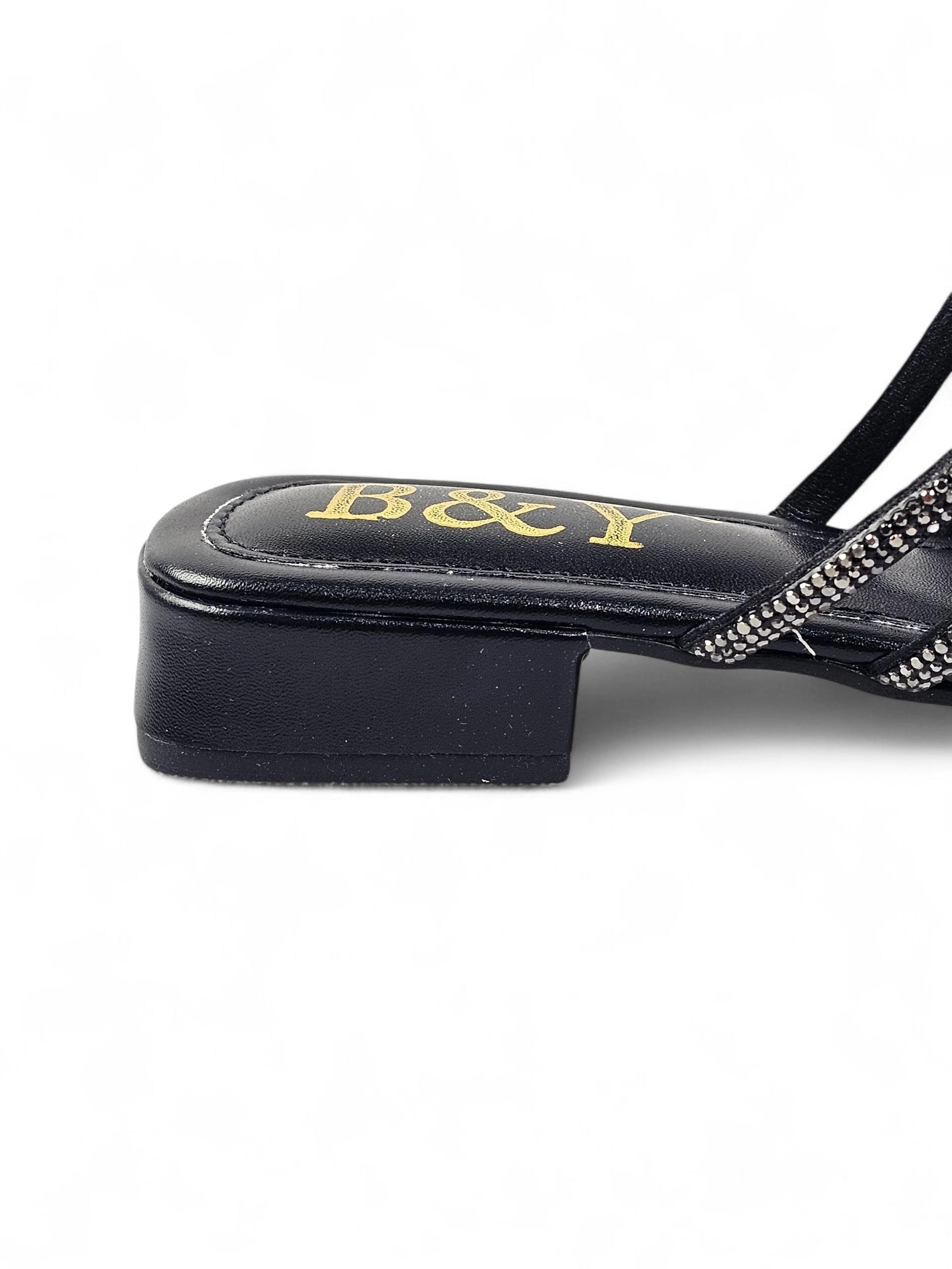 Sandália preta artesanal com tiras entrelaçadas e cristais reluzentes.