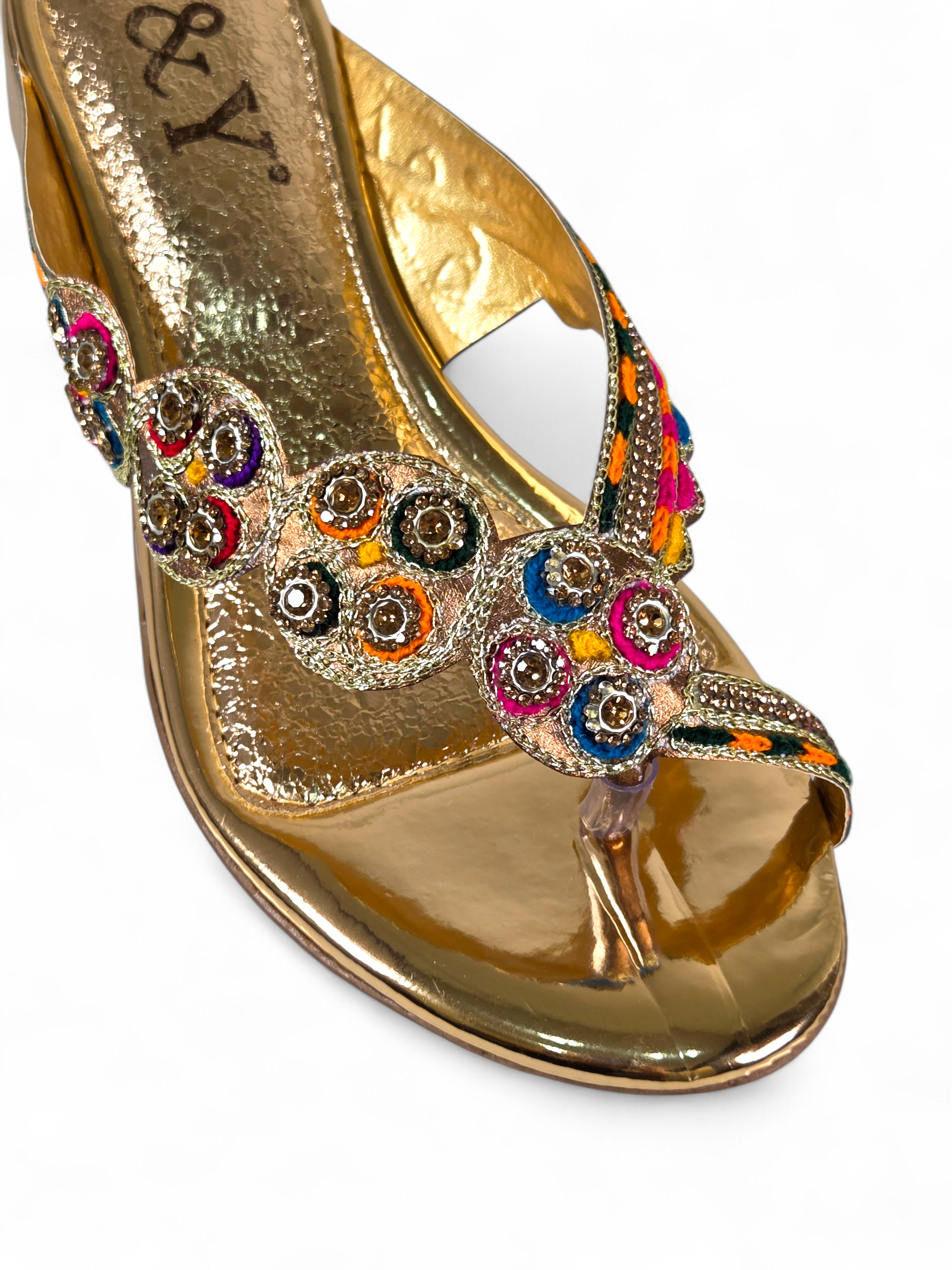 Sandália artesanal B&Y dourada com bordados multicoloridos, aplicação de cristais, salto baixo e acabamento sofisticado, em fundo branco.