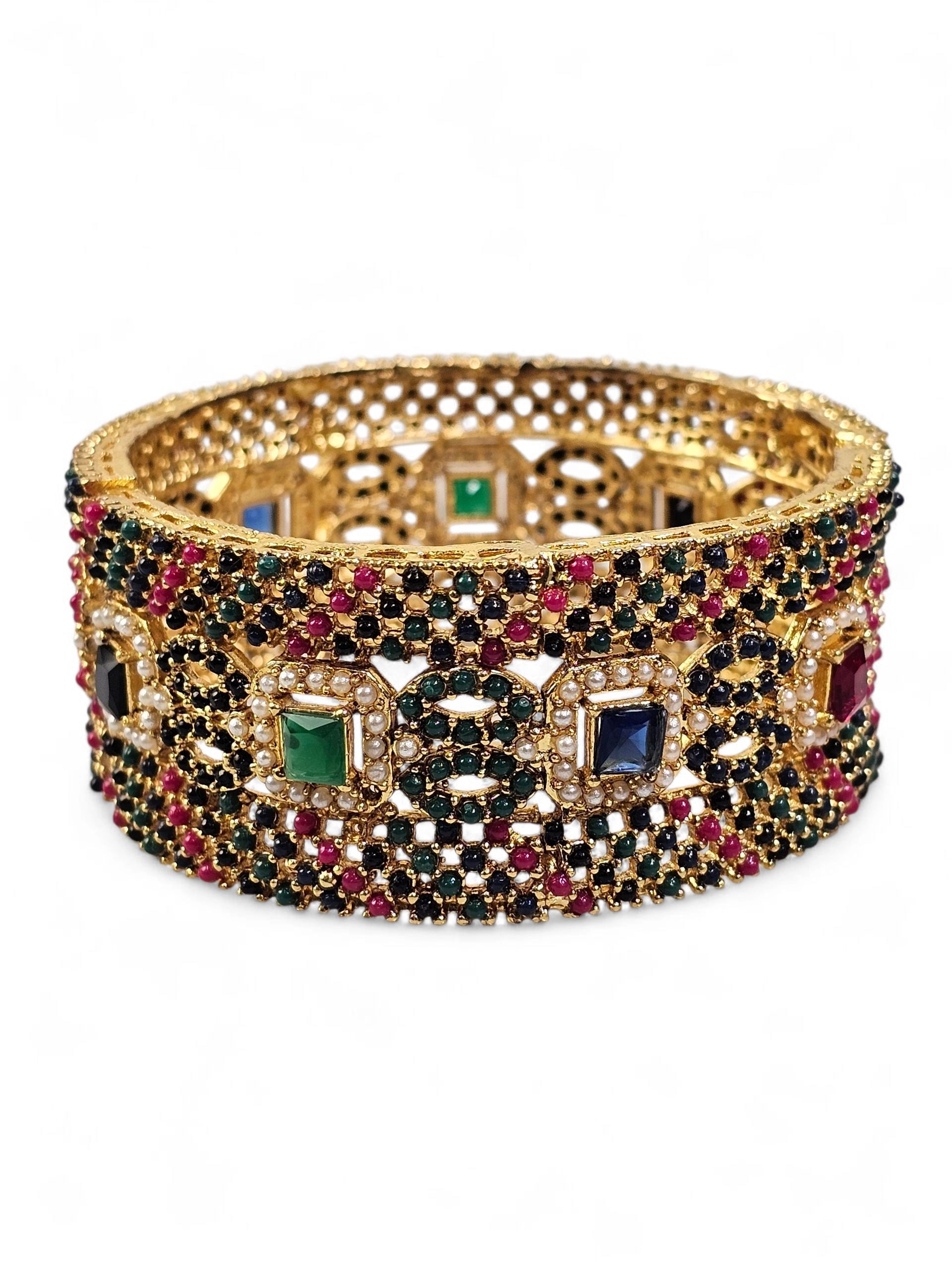 Bracelete artesanal B&Y com pedras verde-esmeralda, azul-safira, douradas e rubi, joia vibrante e elegante.