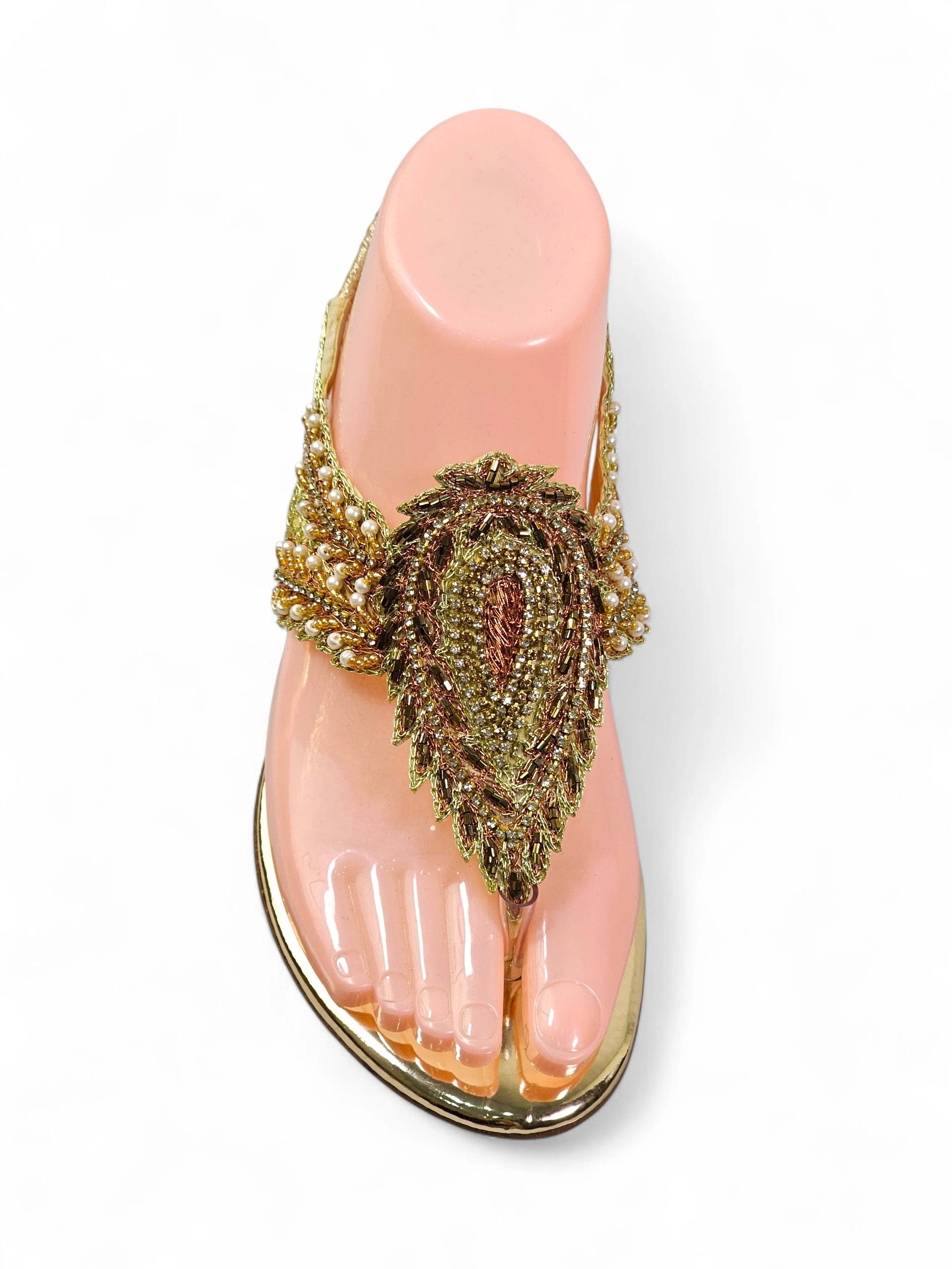 Sandália artesanal feminina dourada feita à mão com bordado de pedrarias e fios metálicos.