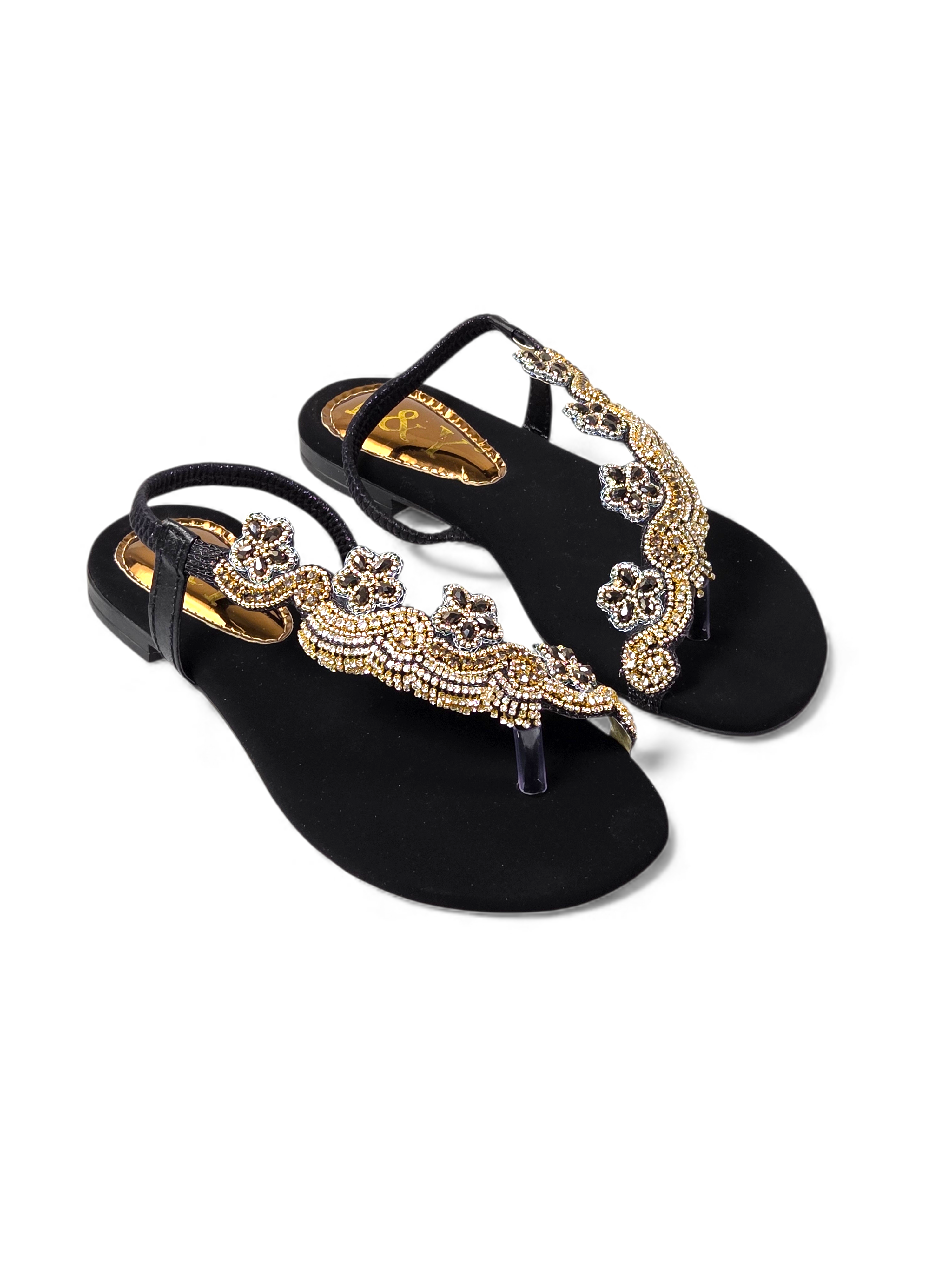 A pair of black, embellished sandals with gold and silver rhinestones or crystals on the toe and heel.
