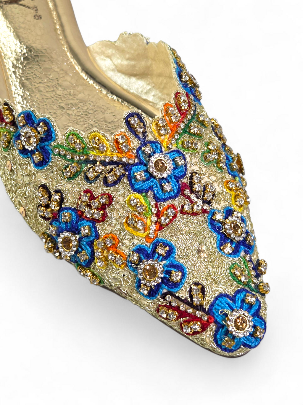 Mule artesanal dourada com bordado floral multicolorido feito à mão e pedrarias brilhantes.