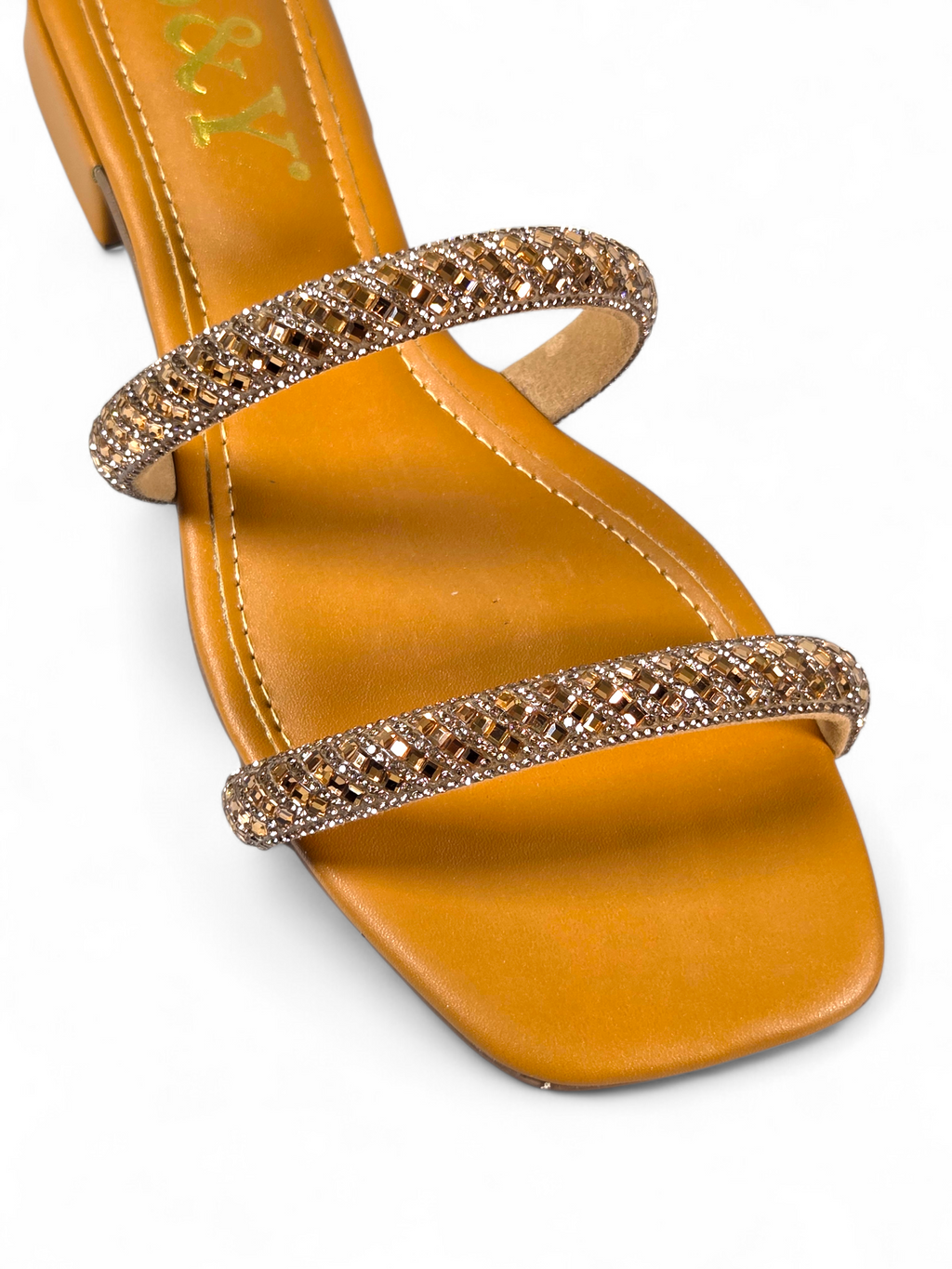 Sandália artesanal B&Y em tom quente com duas tiras cravejadas de cristais, salto baixo e acabamento sofisticado, em fundo branco.
