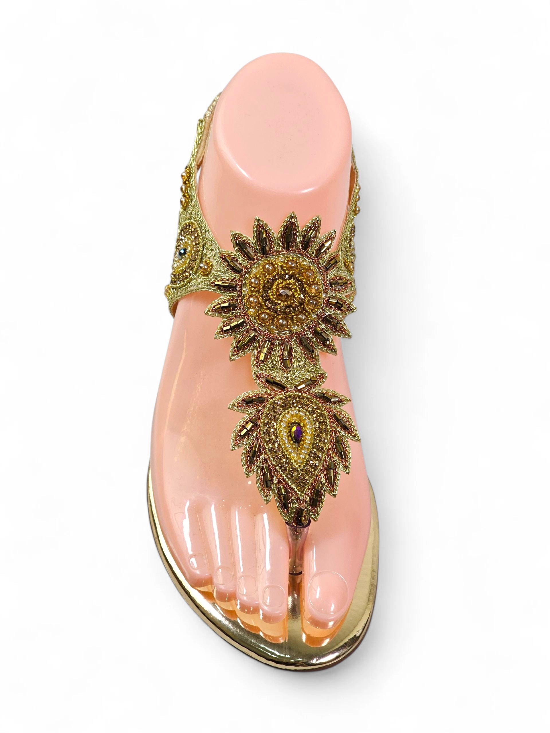 Sandália artesanal dourada com flores bordadas à mão em tons de dourado, âmbar, bronze e pérola, com design em formato de girassol.