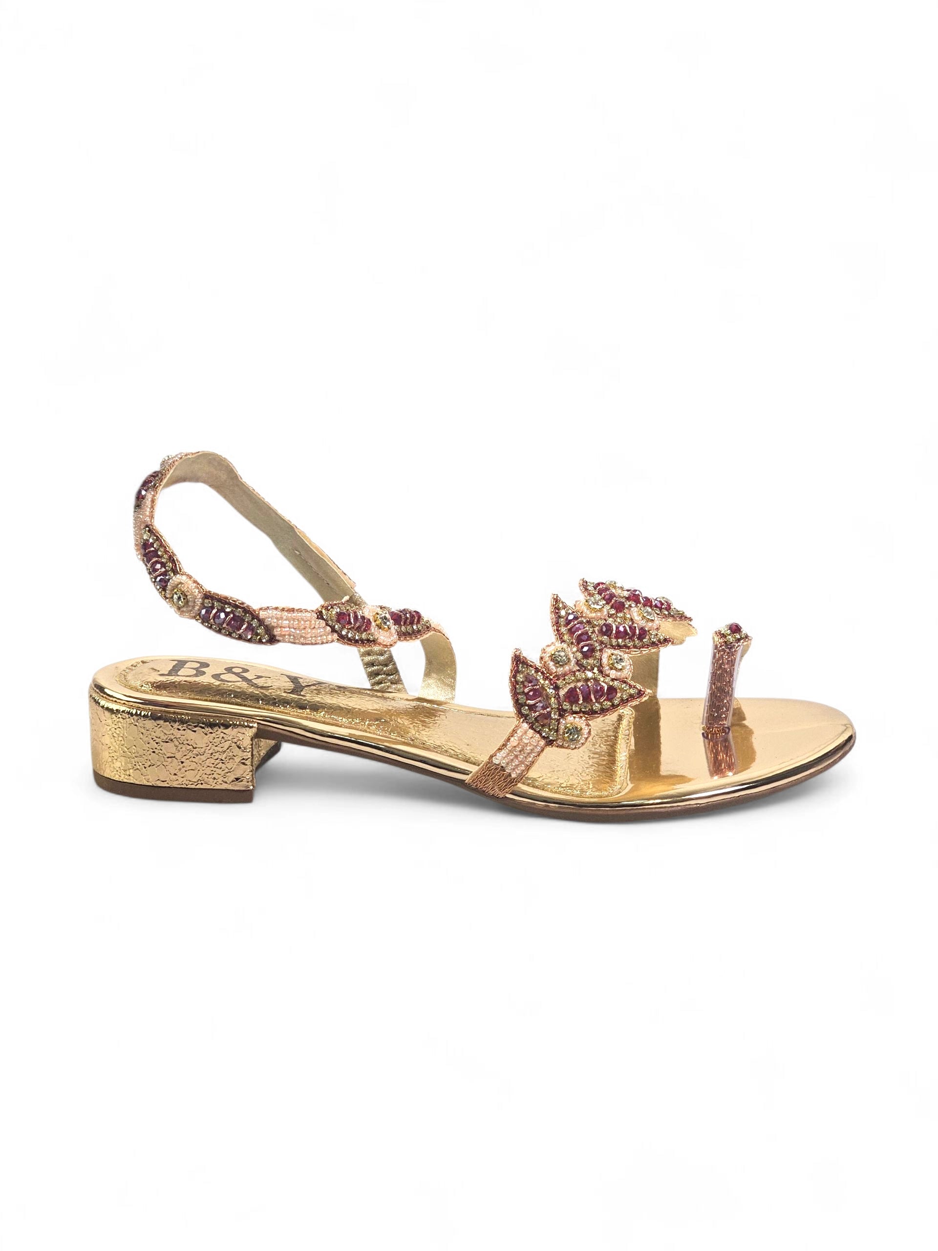 Sandália artesanal dourada com pedrarias rubi e pérolas, design em folhas, feita à mão com miçangas e brilho sofisticado.