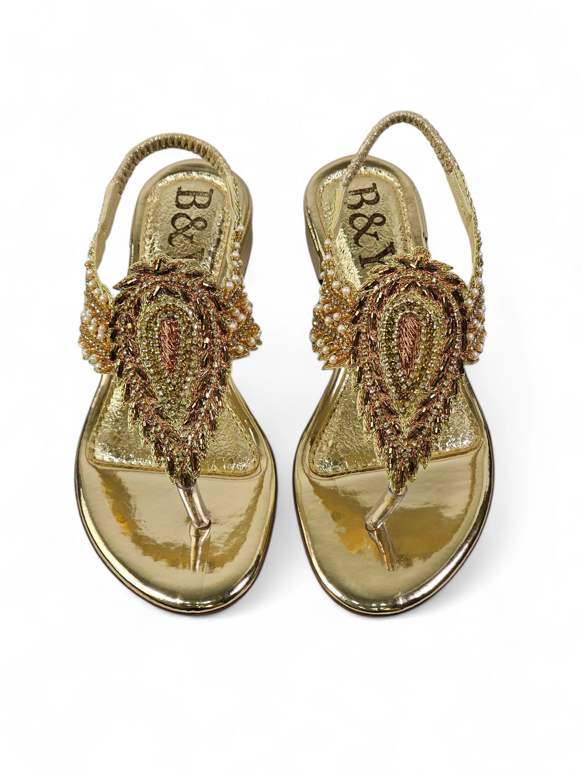 Sandália artesanal feminina dourada feita à mão com bordado de pedrarias e fios metálicos.