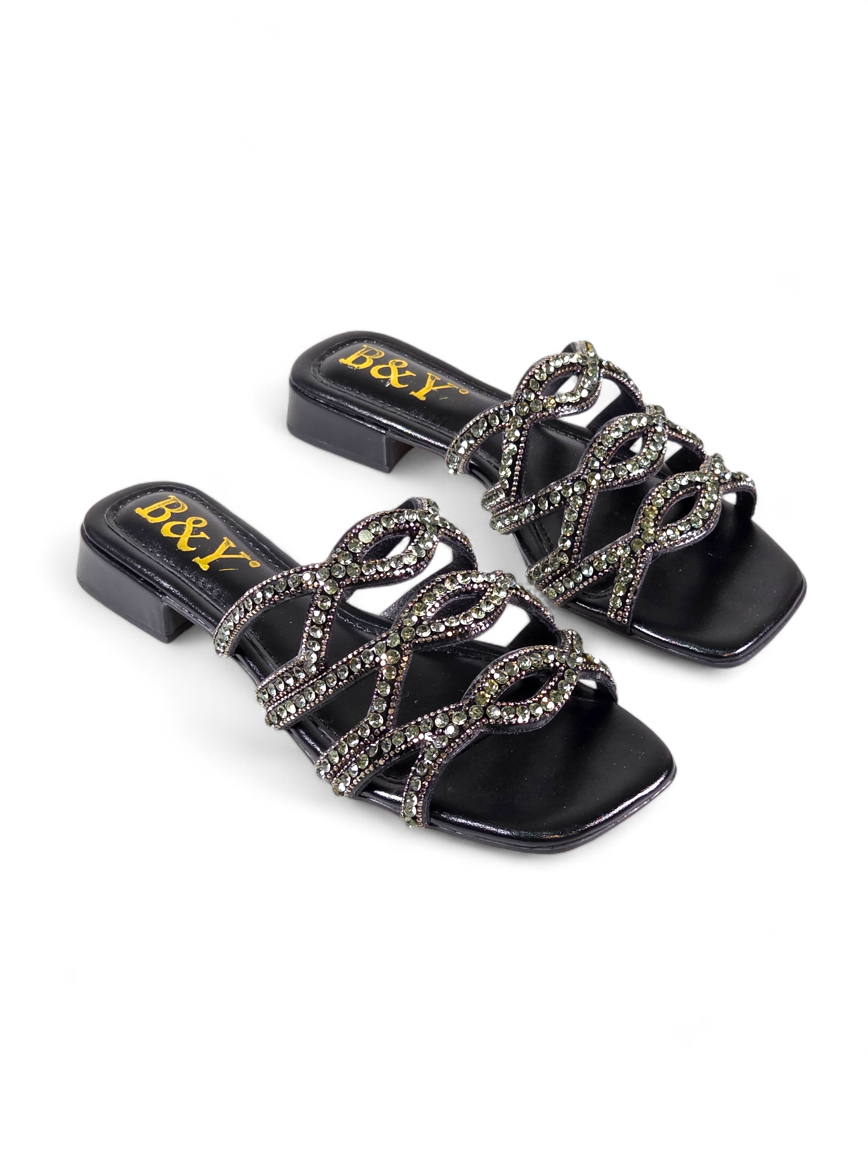 Sandália artesanal B&Y preta com tiras entrelaçadas cravejadas de cristais, salto baixo e acabamento sofisticado, em fundo branco.