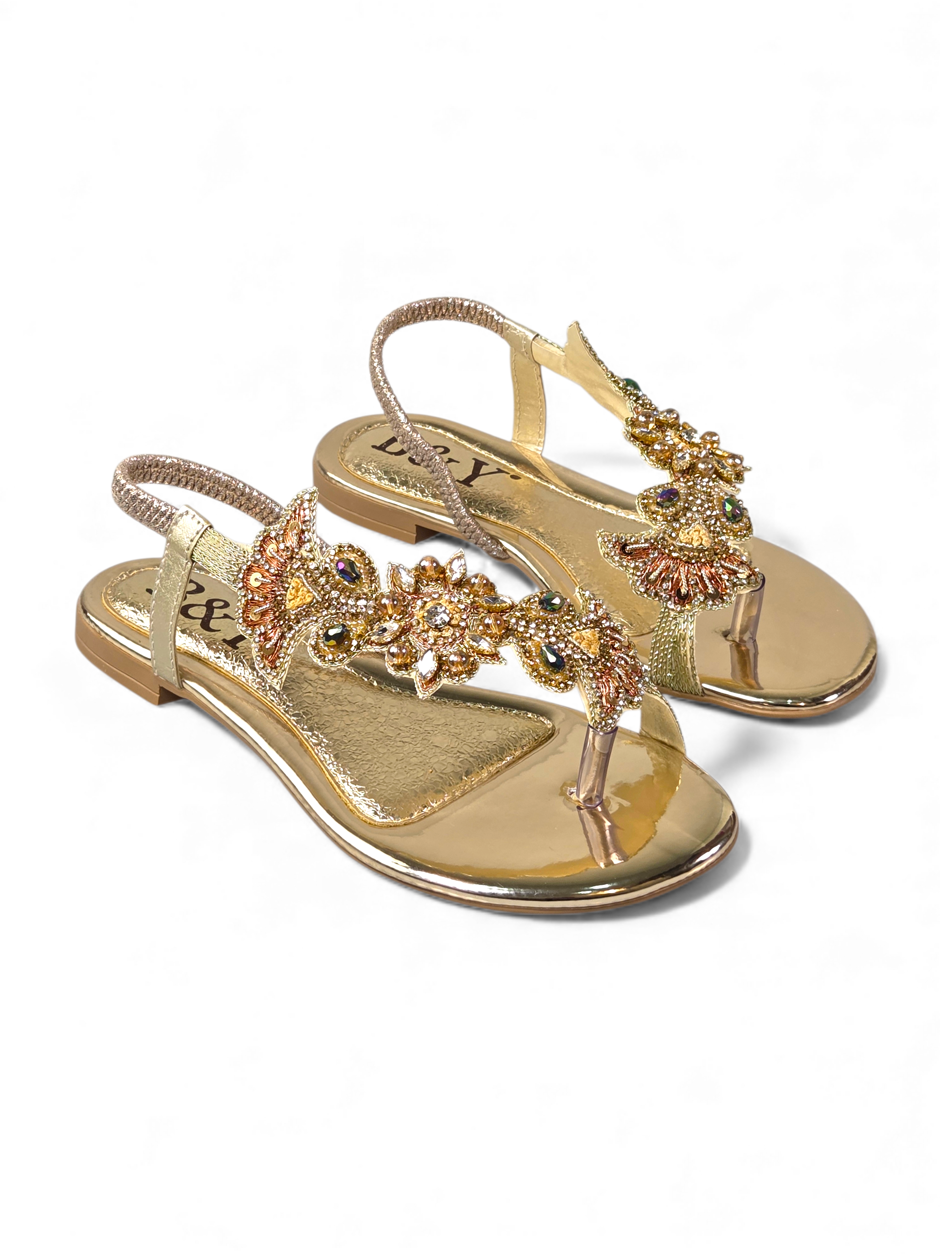 A pair of gold sandals with intricate floral embellishments.