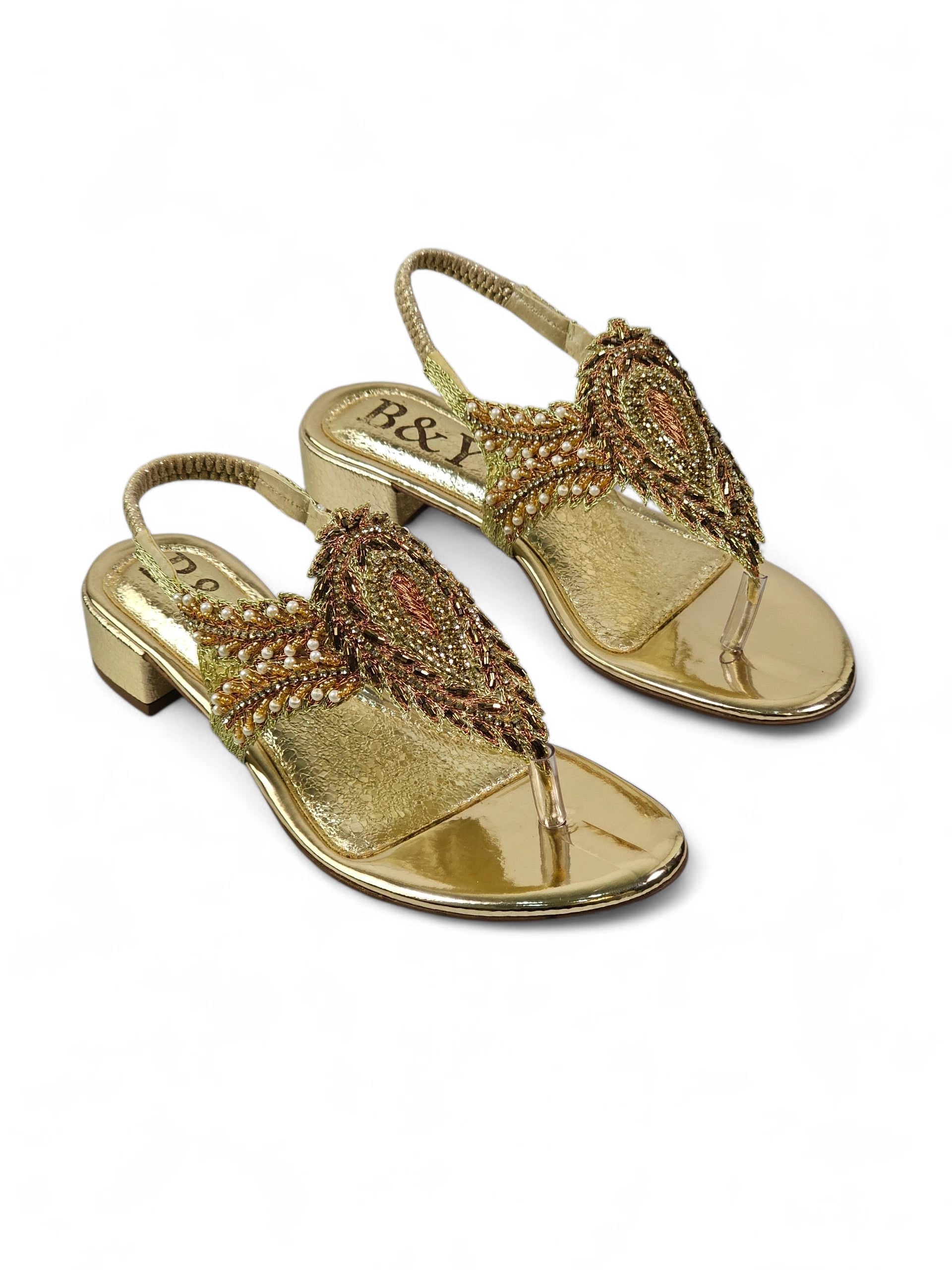 Sandália artesanal feminina dourada feita à mão com bordado de pedrarias e fios metálicos.