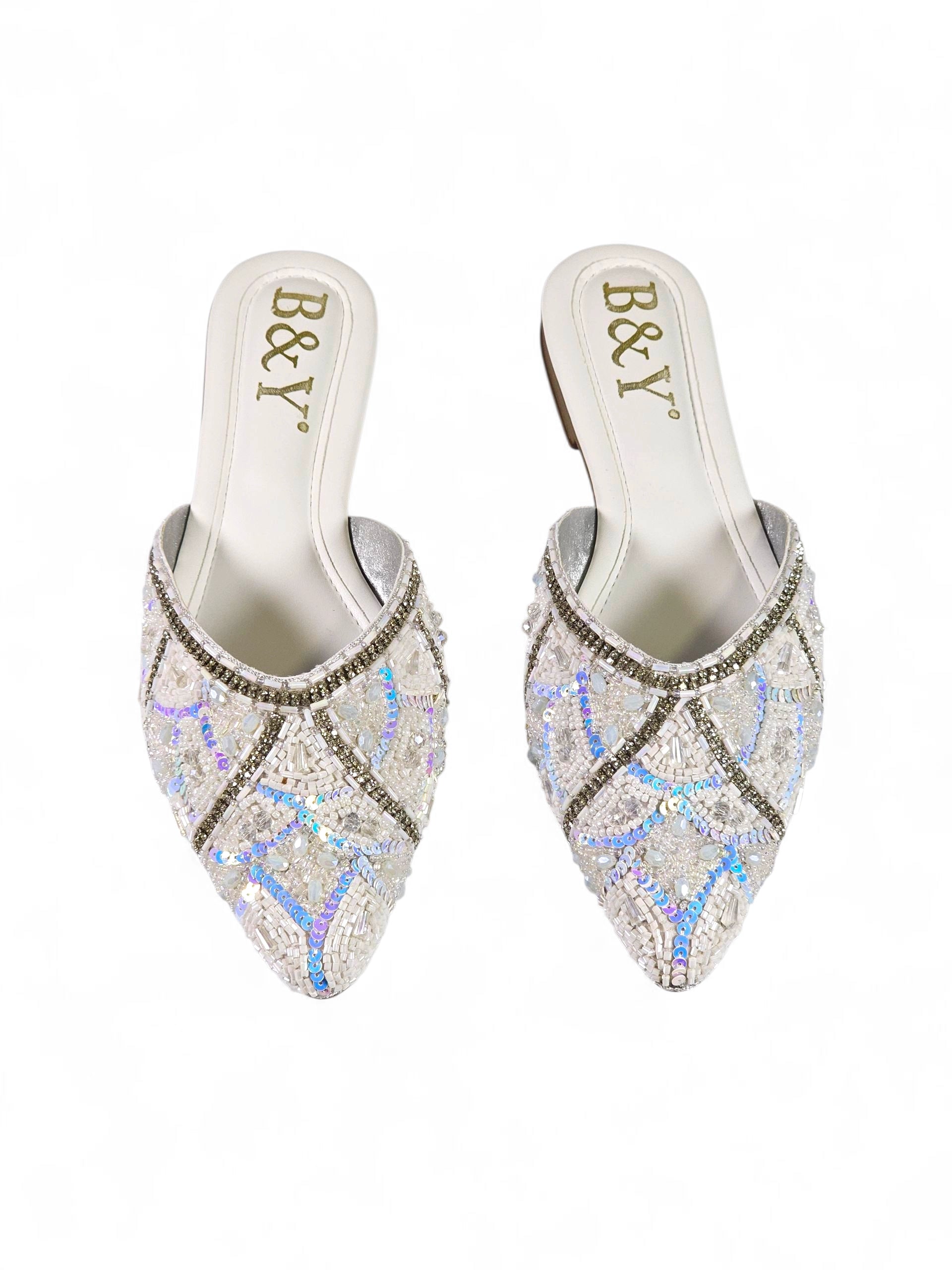 Mule artesanal B&Y branco com bordados de miçangas brancas, cristais prateados e reflexos azul e lilás.