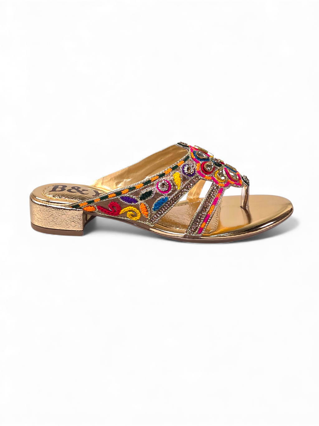 A gold-colored sandal with a floral pattern and beaded embellishments.