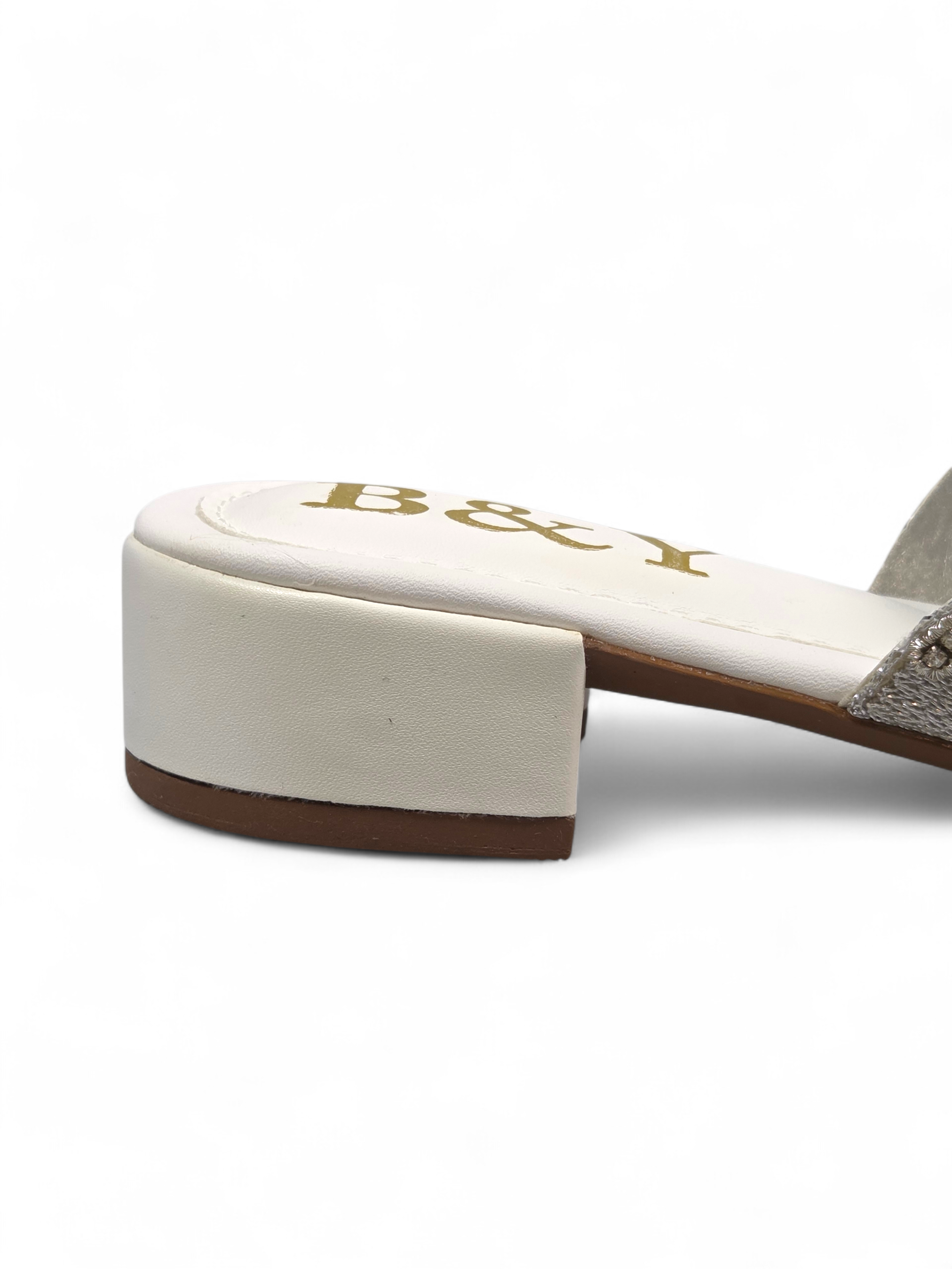 Sandália artesanal B&Y em tom creme com bordado manual em pedrarias douradas, cristais delicados e design floral orgânico, salto baixo e acabamento sofisticado.