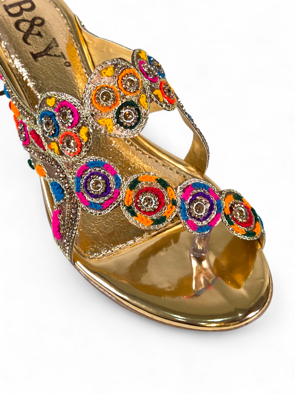 Sandália artesanal B&Y dourada com bordados multicoloridos, aplicação de cristais, salto baixo e acabamento sofisticado, em fundo branco.