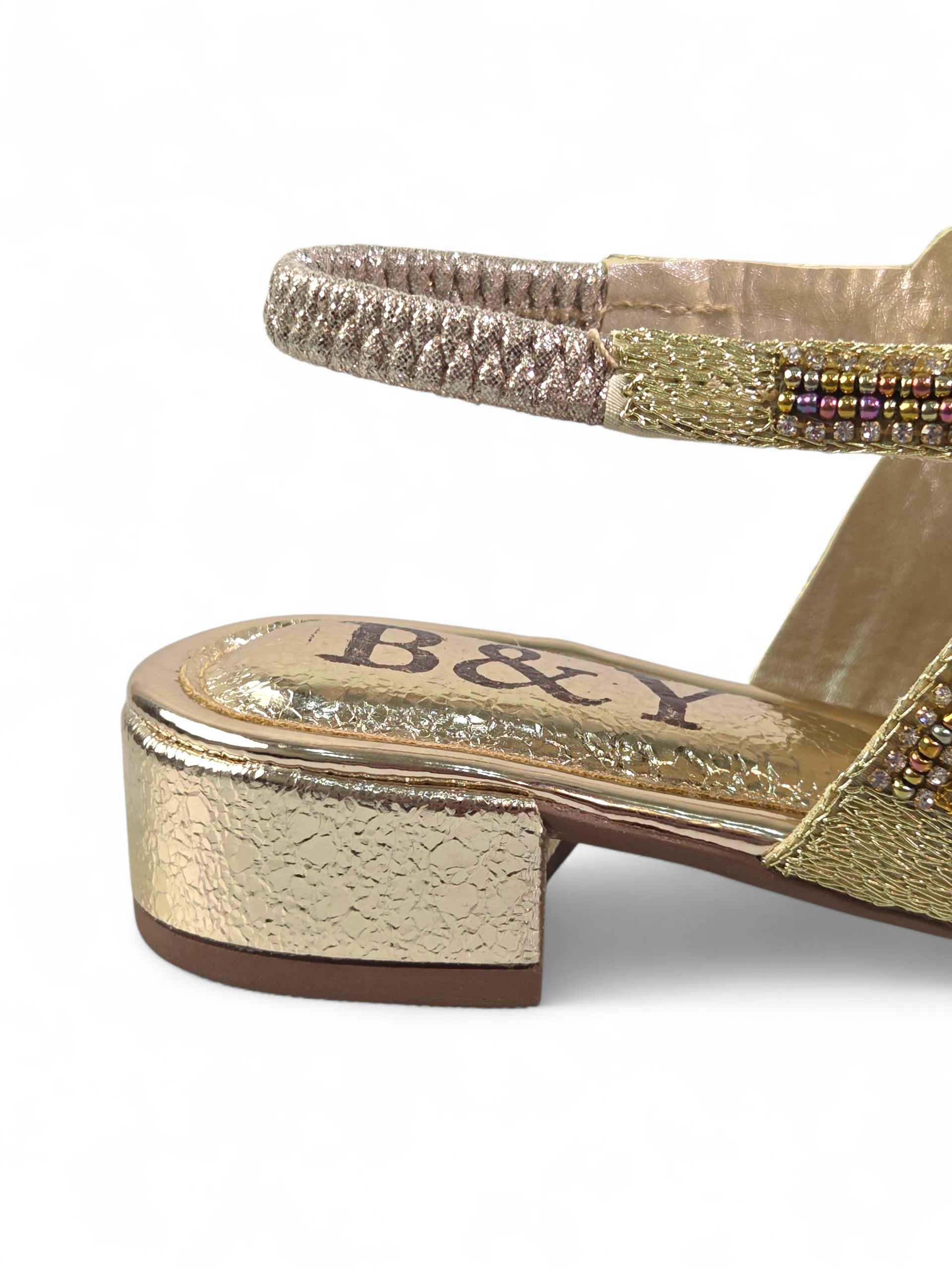 Sandália artesanal dourada bordada à mão com pedrarias coloridas em dourado, azul-marinho, verde, cobre, lilás e âmbar, com salto baixo espelhado.