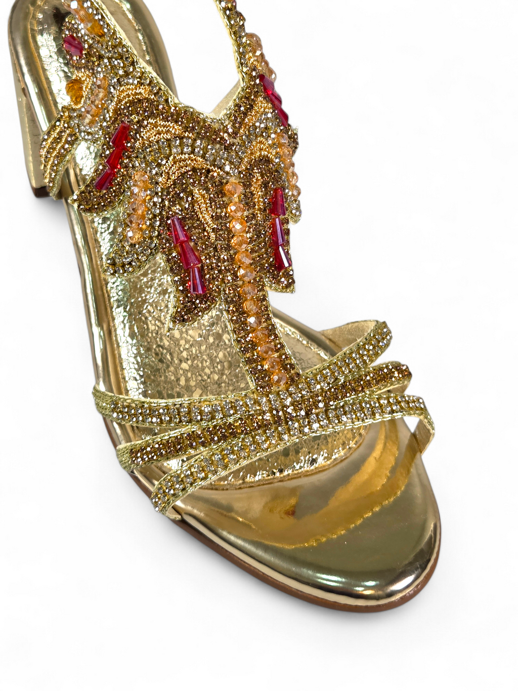 Sandália artesanal B&Y dourada com bordados manuais, cristais e pedrarias em tons de dourado e vermelho, salto médio e acabamento sofisticado, em fundo branco.