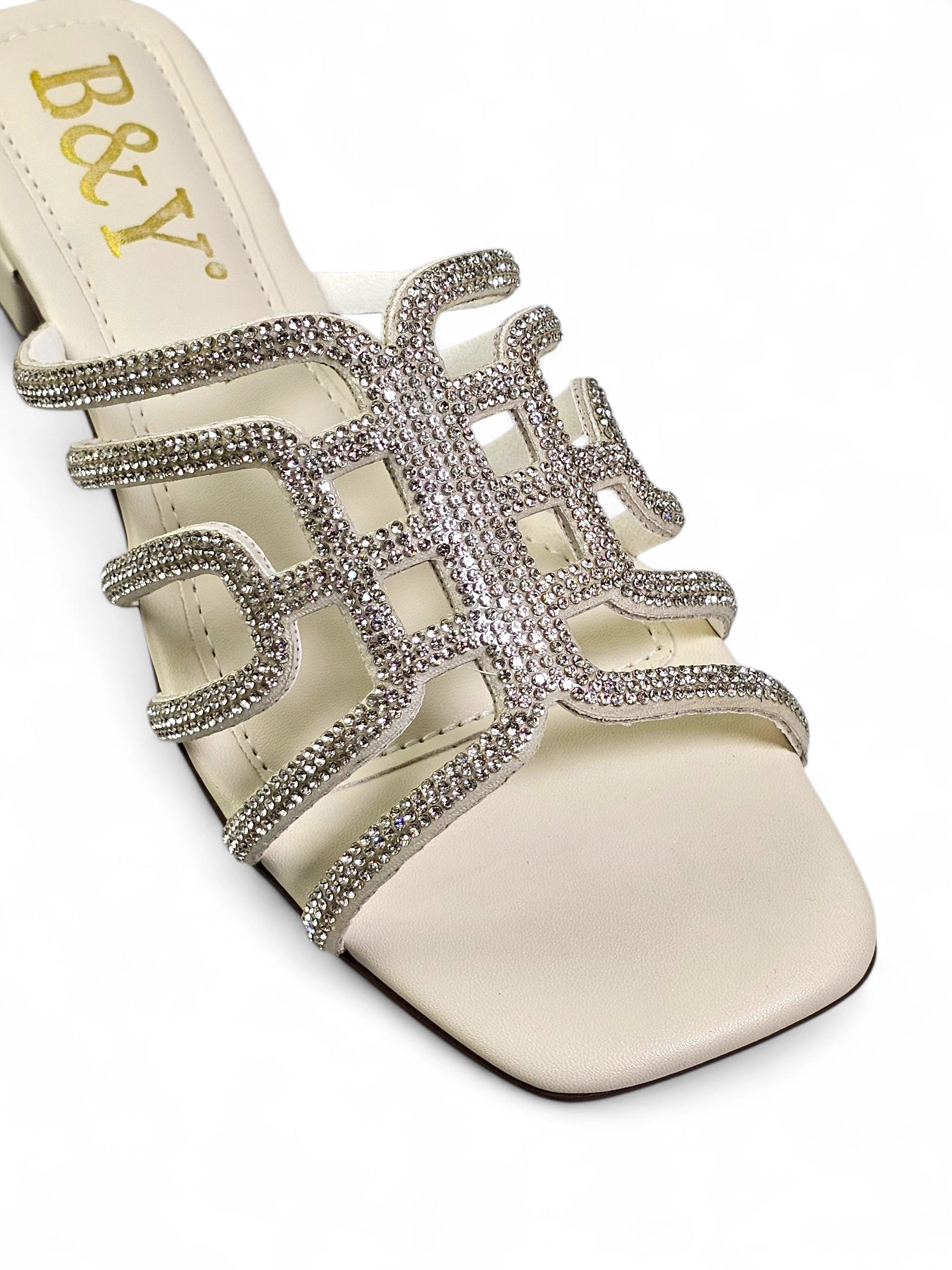 Sandália branca artesanal com tiras entrelaçadas e cristais brilhantes.