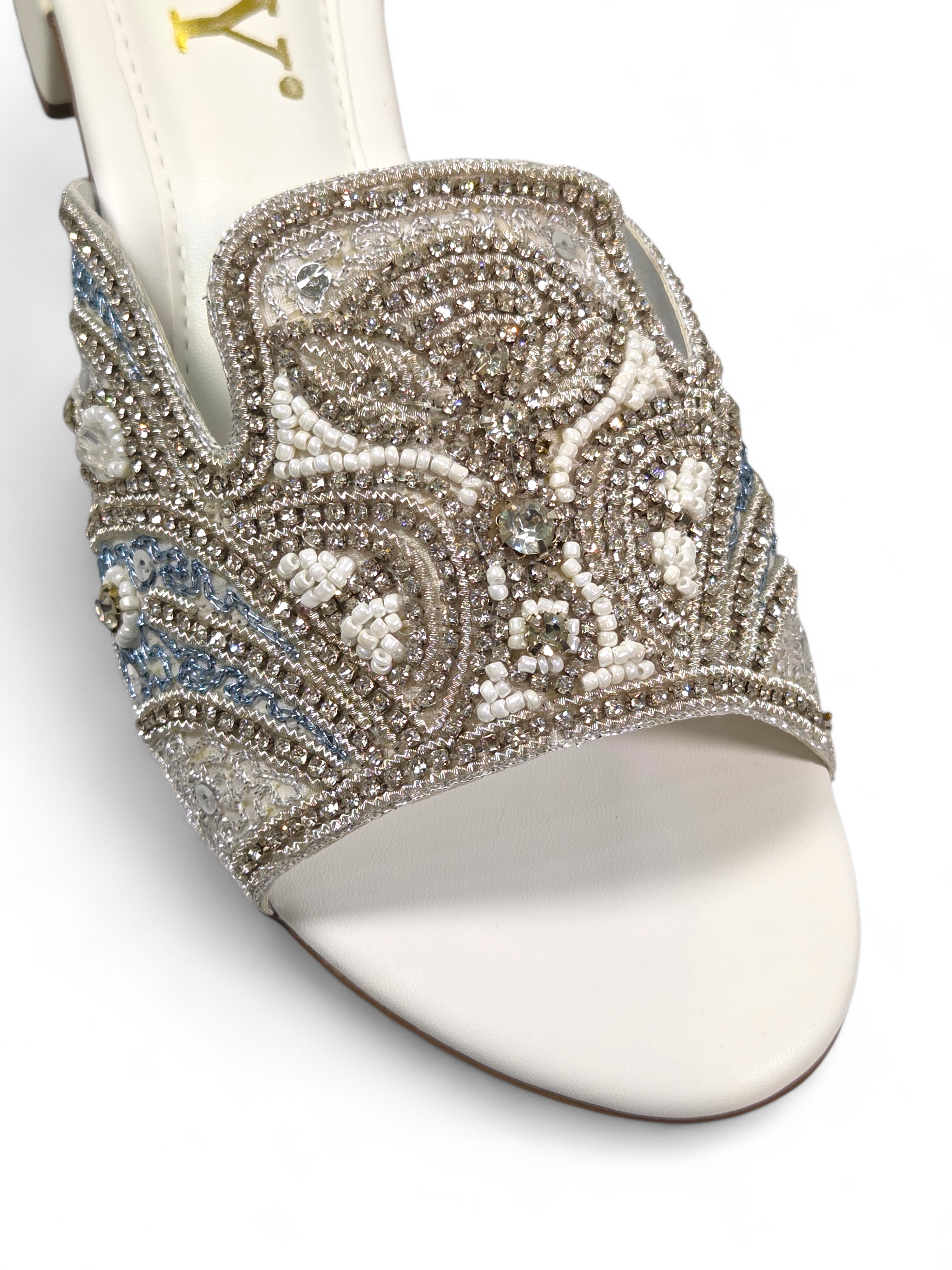 Sandália artesanal B&Y em tom creme com bordado manual em pedrarias douradas, cristais delicados e design floral orgânico, salto baixo e acabamento sofisticado.