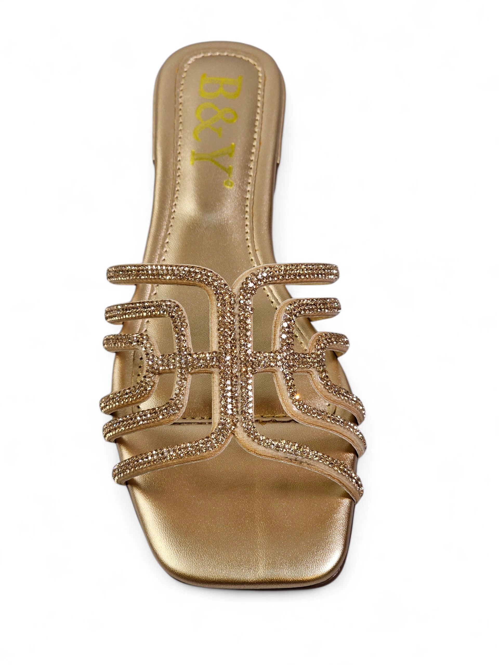 Sandália dourada artesanal com tiras entrelaçadas e cristais cintilantes.