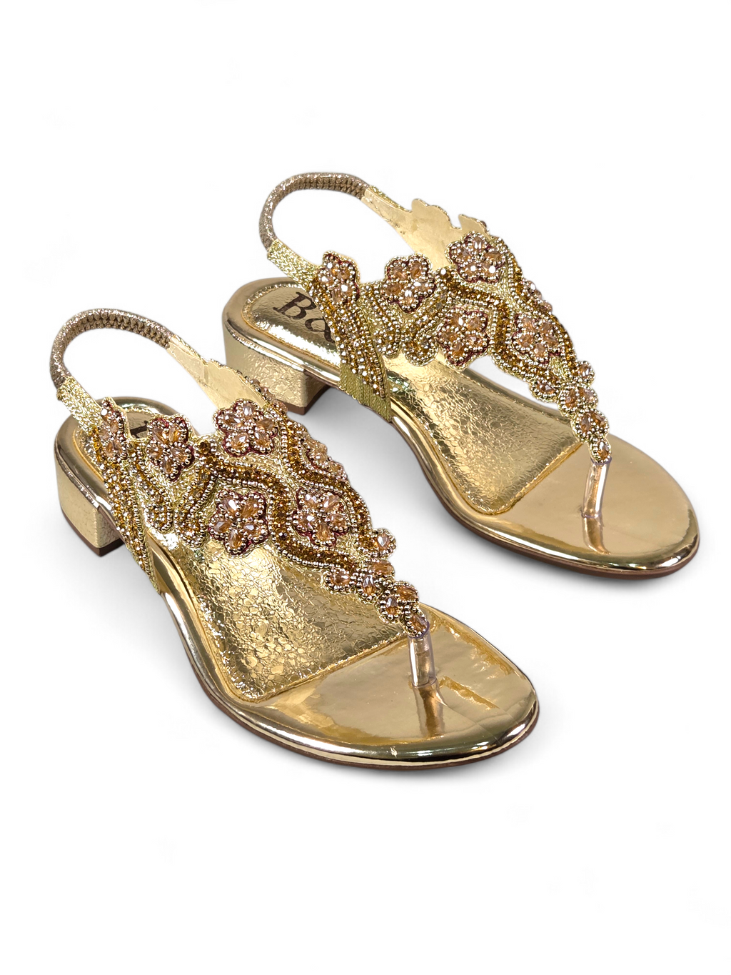 Sandália artesanal B&Y dourada com bordados florais, aplicação de cristais, fechamento no calcanhar e salto baixo, em fundo branco.