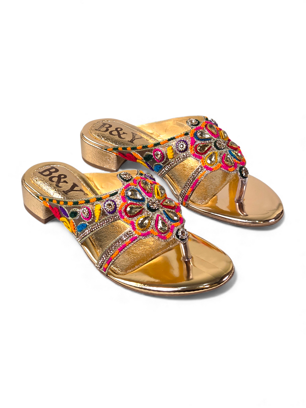 A pair of gold-colored, embellished sandals with a floral design.