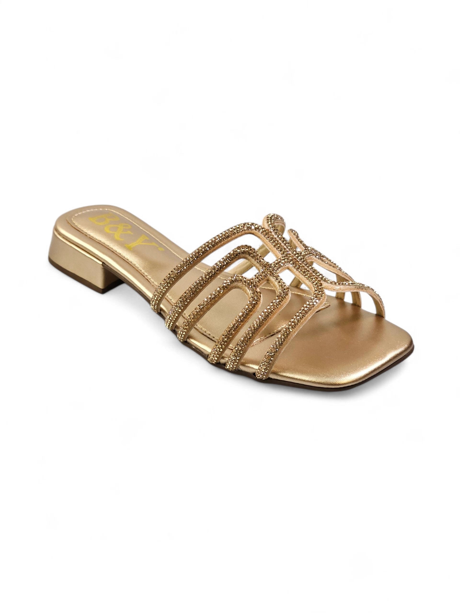 Sandália dourada artesanal com tiras entrelaçadas e cristais cintilantes.