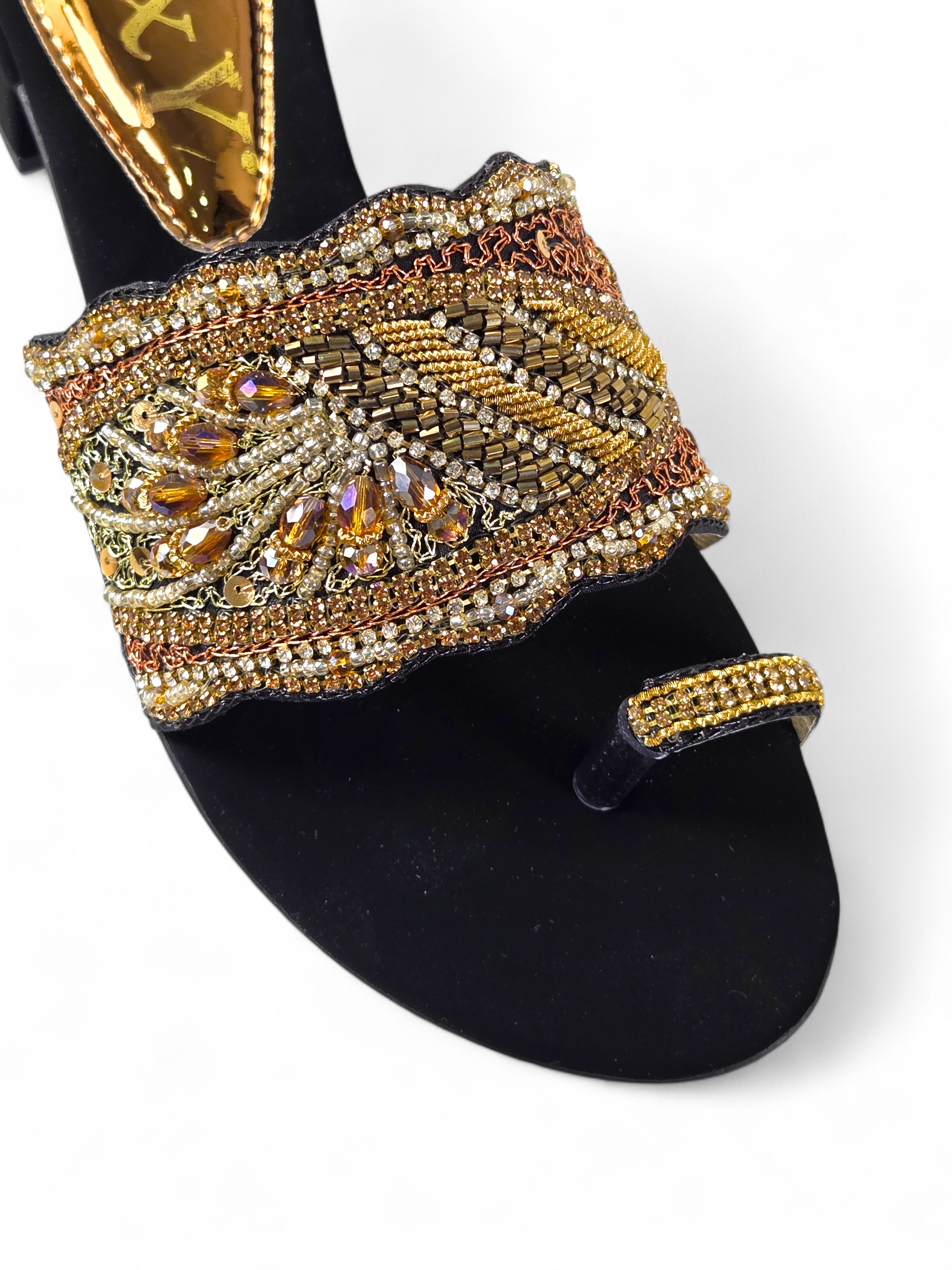 Sandália artesanal B&Y preta com pala bordada à mão, aplicação de cristais dourados, salto baixo e acabamento sofisticado, em fundo branco.