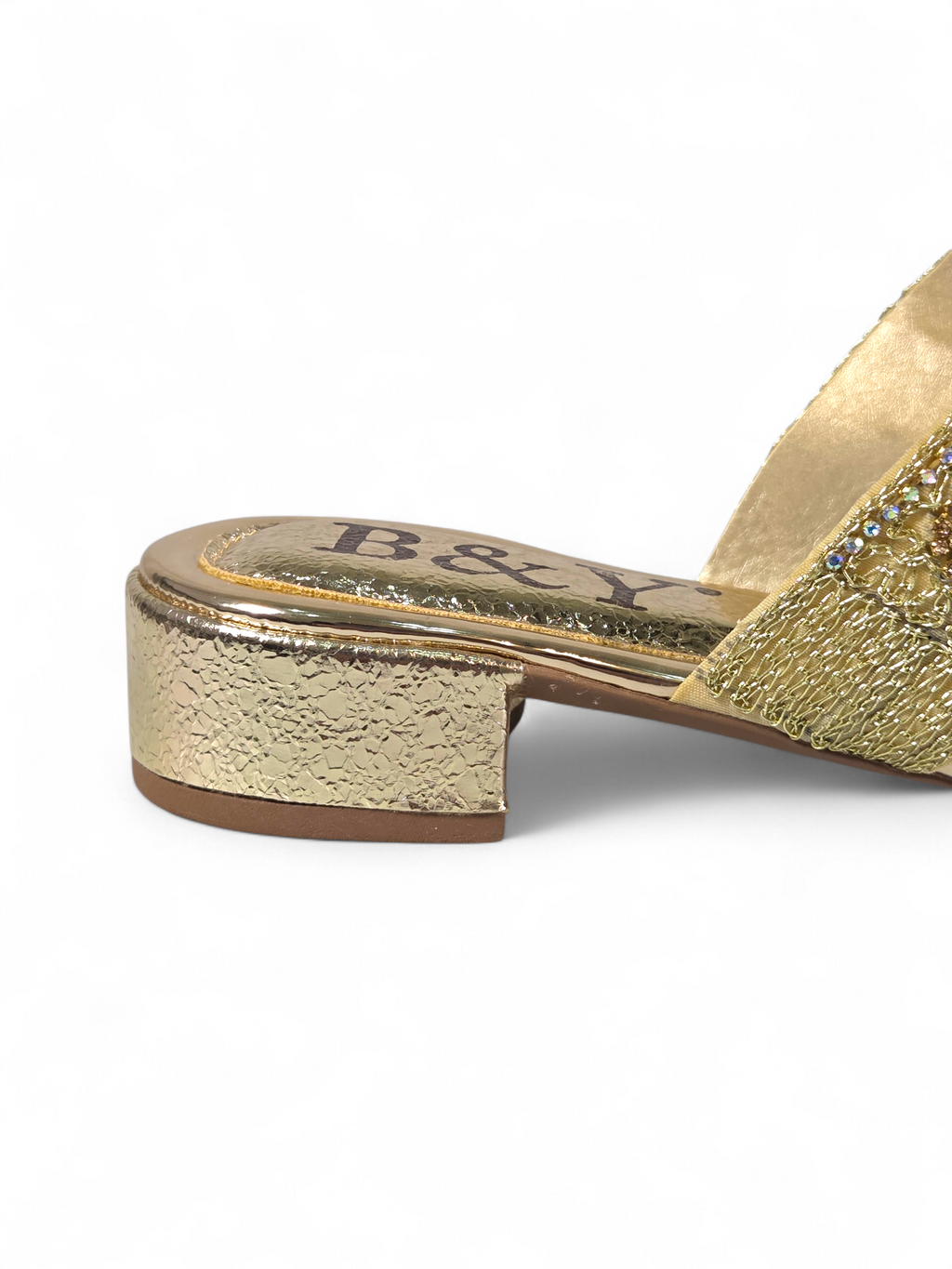 Sandália artesanal B&Y dourada com tiras bordadas, aplicação de cristais e salto baixo, fotografada em fundo branco.