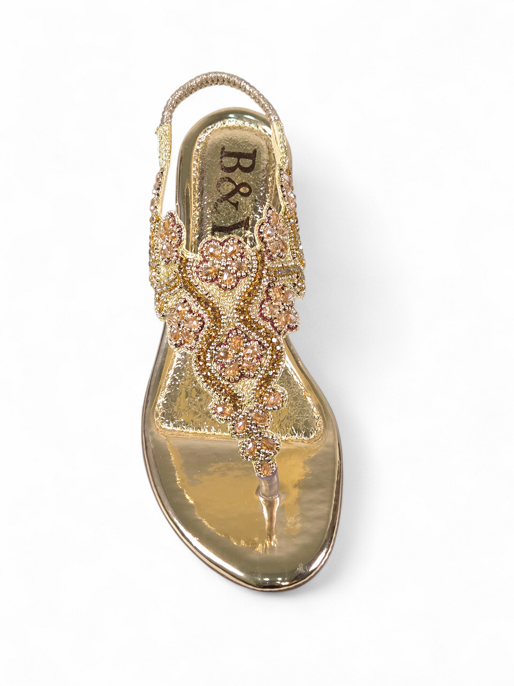 Sandália artesanal B&Y dourada com bordados florais, aplicação de cristais, fechamento no calcanhar e salto baixo, em fundo branco.