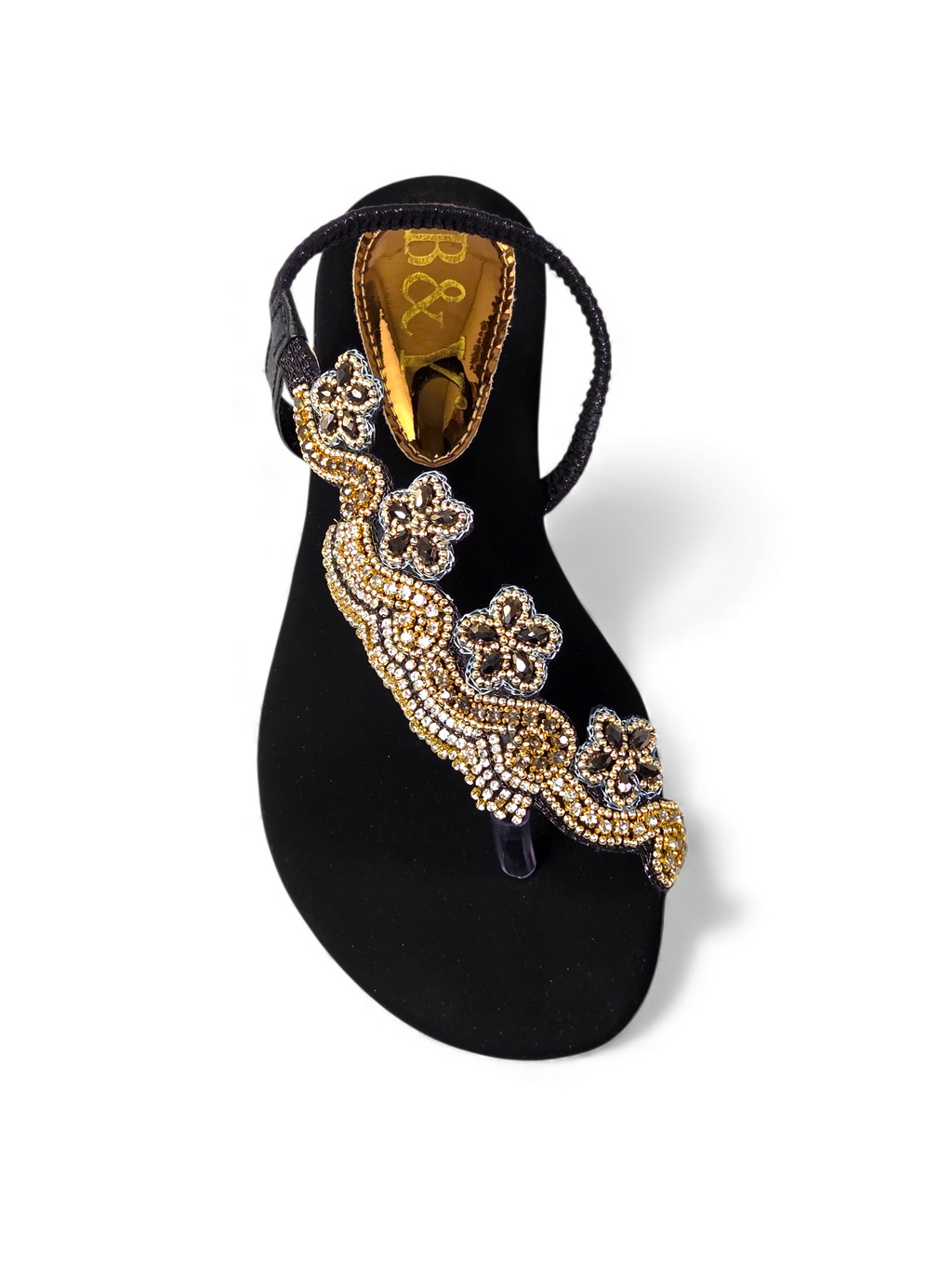 A black sandal with a decorative floral embellishment on the toe area.