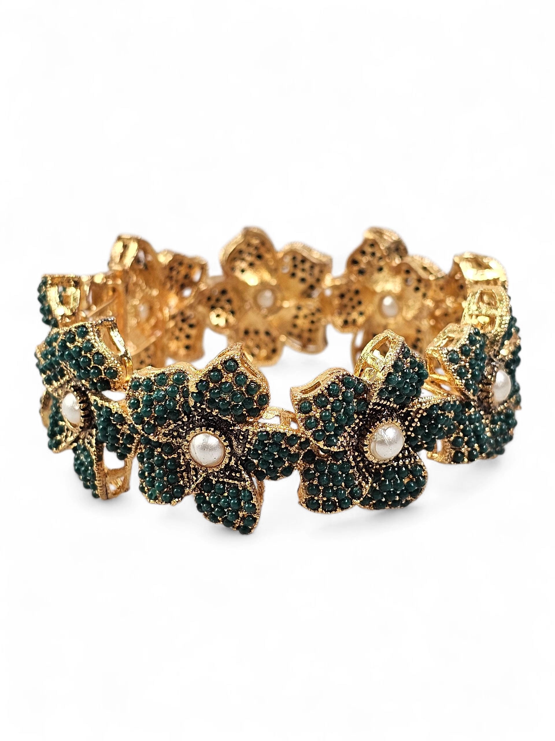 Bracelete floral B&Y com flores verde-esmeralda, detalhes dourados e pérolas no centro.
