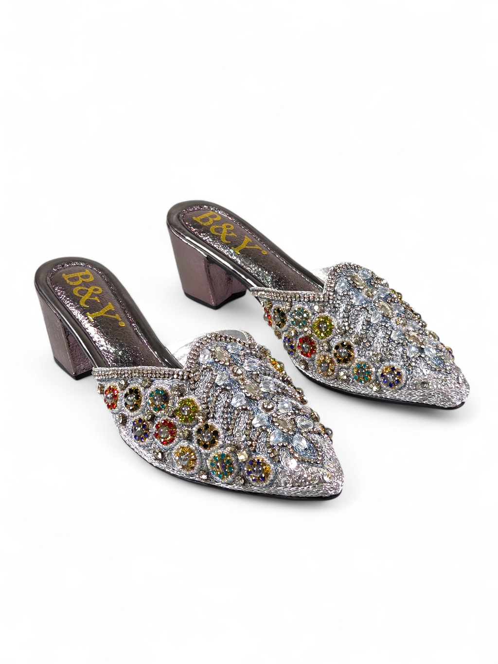 A pair of silver, pointed heeled shoes adorned with colorful rhinestones and embellishments.