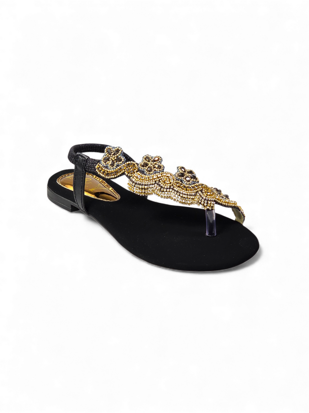 A black sandal with a decorative gold embellishment on the toe area.