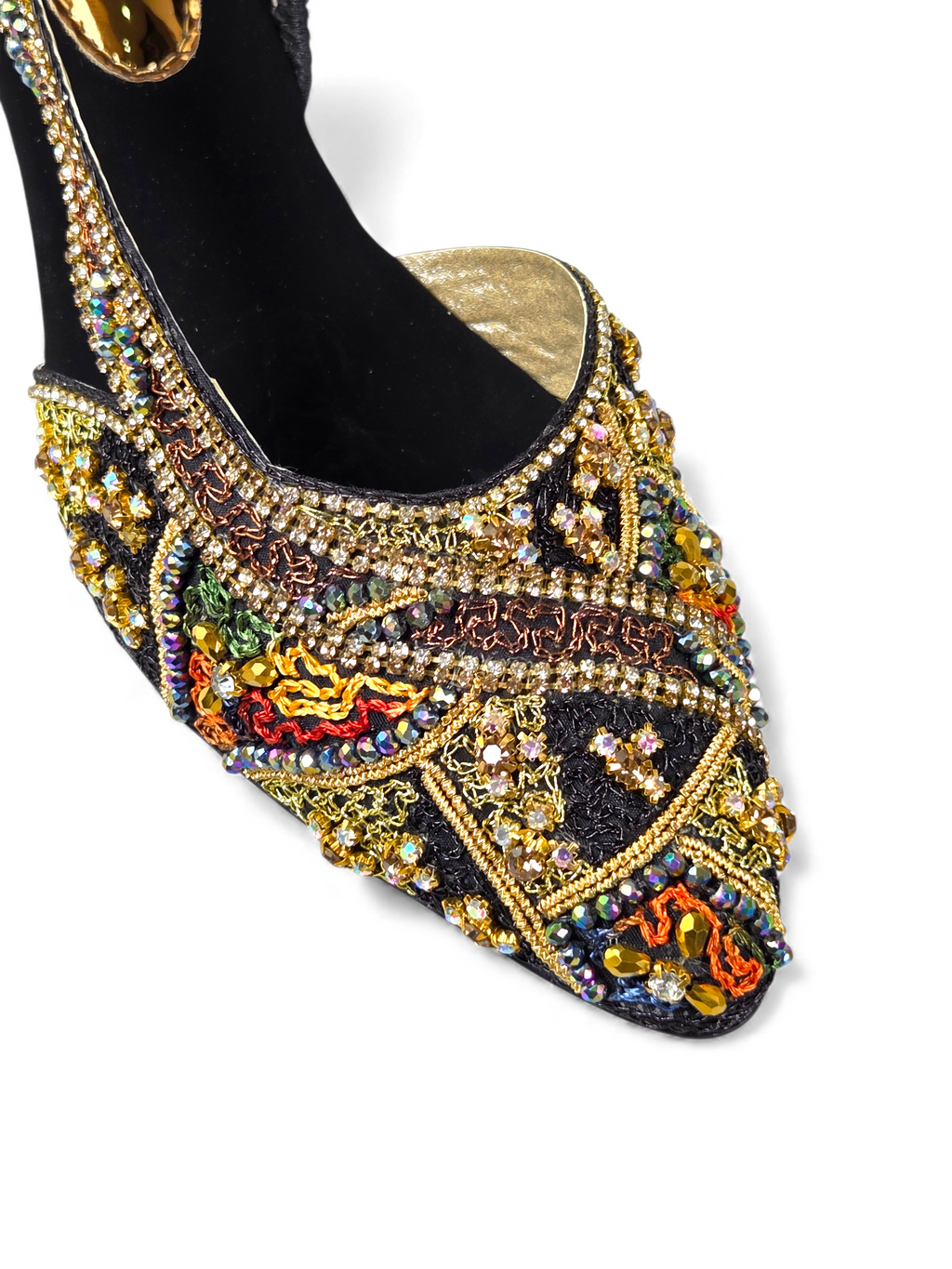 A close-up view of a decorative, embellished shoe with a black sole and gold accents.