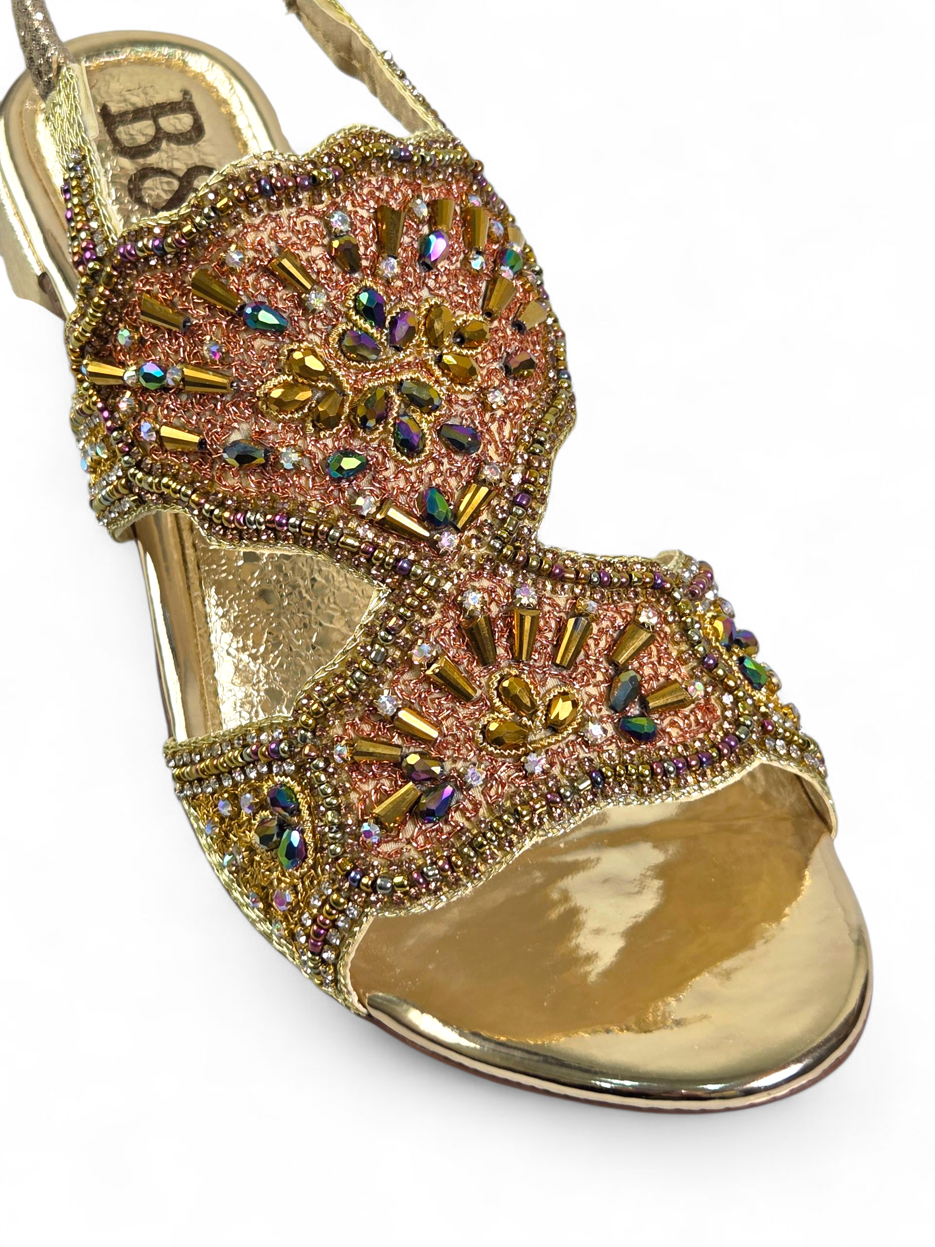 Sandália artesanal dourada bordada à mão com pedrarias coloridas em dourado, azul-marinho, verde, cobre, lilás e âmbar, com salto baixo espelhado.