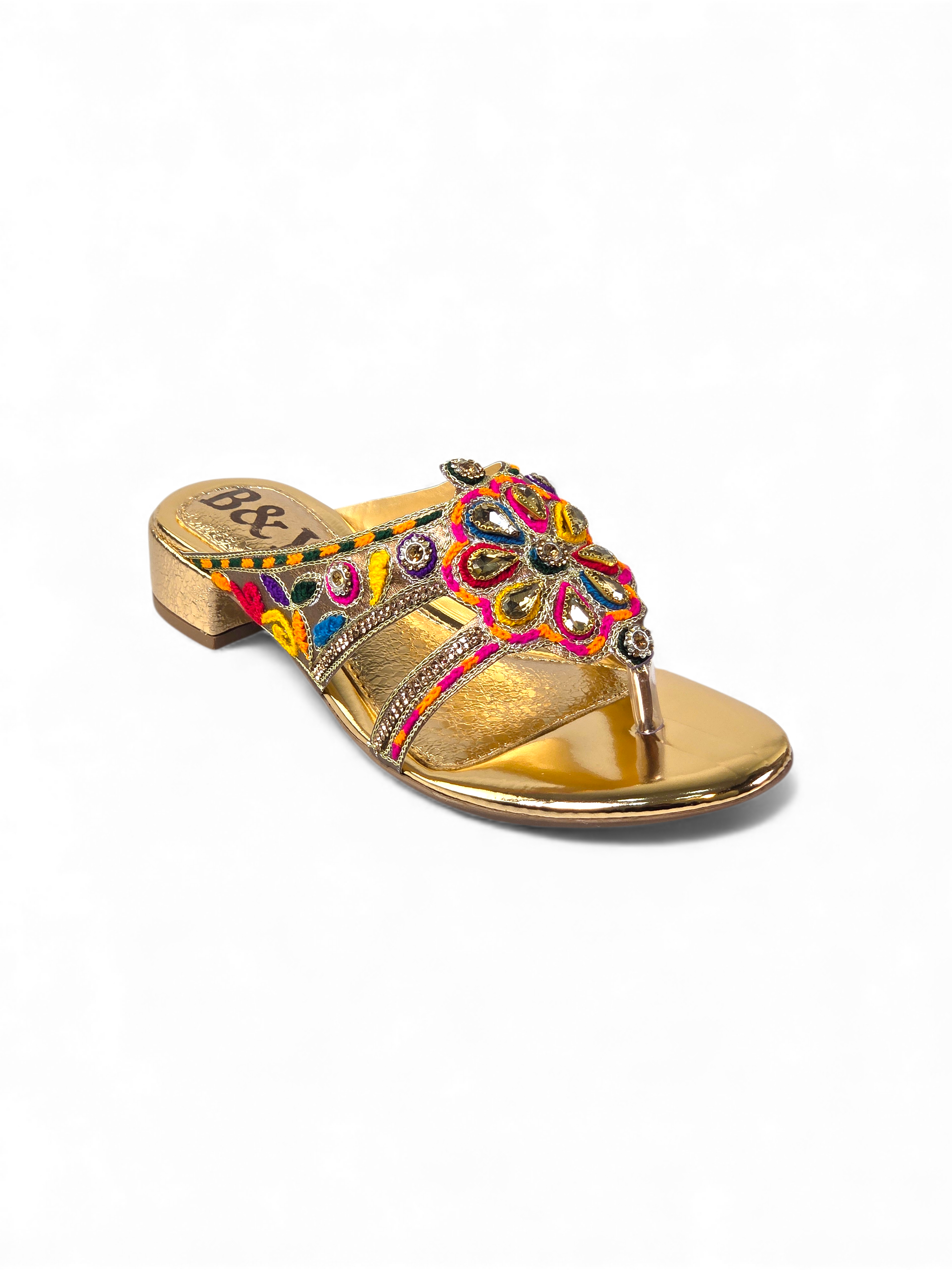 A gold-colored sandal with a floral embellishment on the toe area.