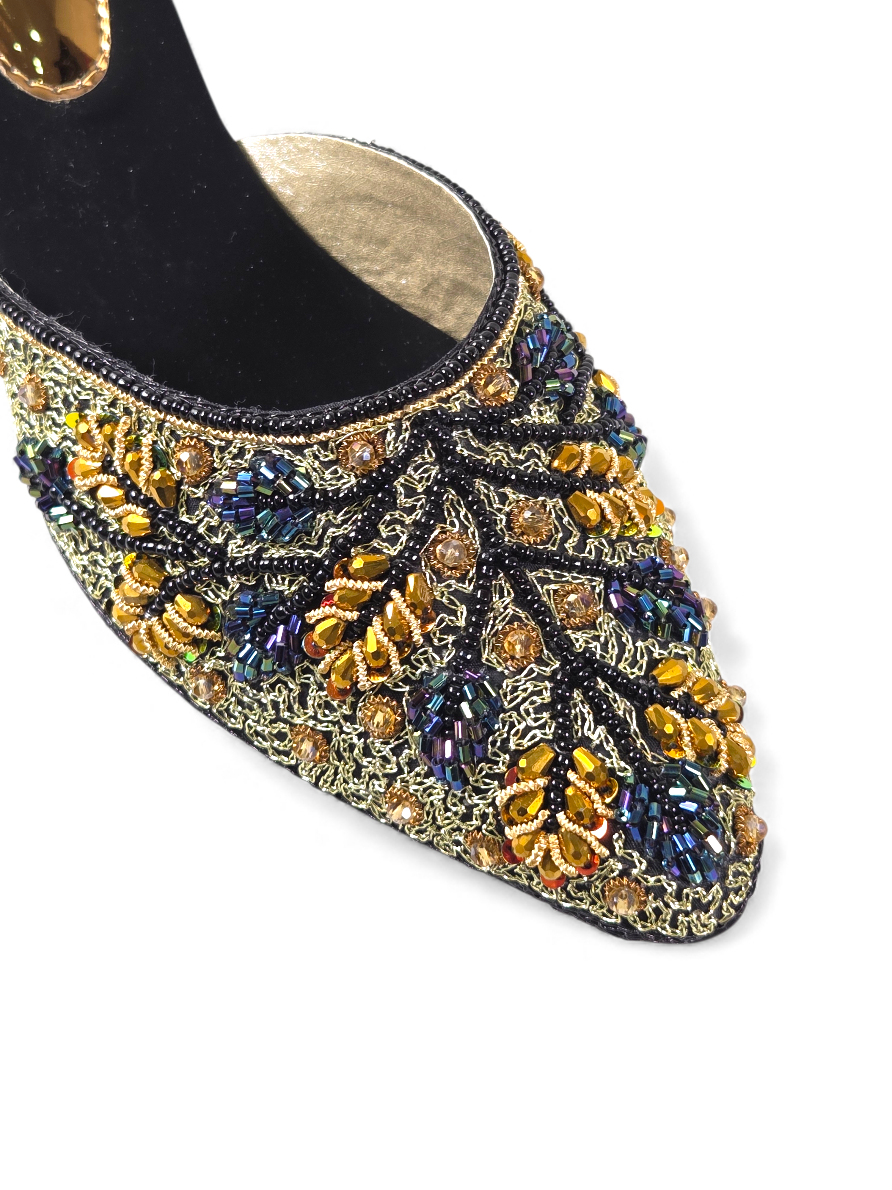 A close-up view of a decorative, embellished shoe with intricate patterns and designs, including gold, blue, and yellow elements.
