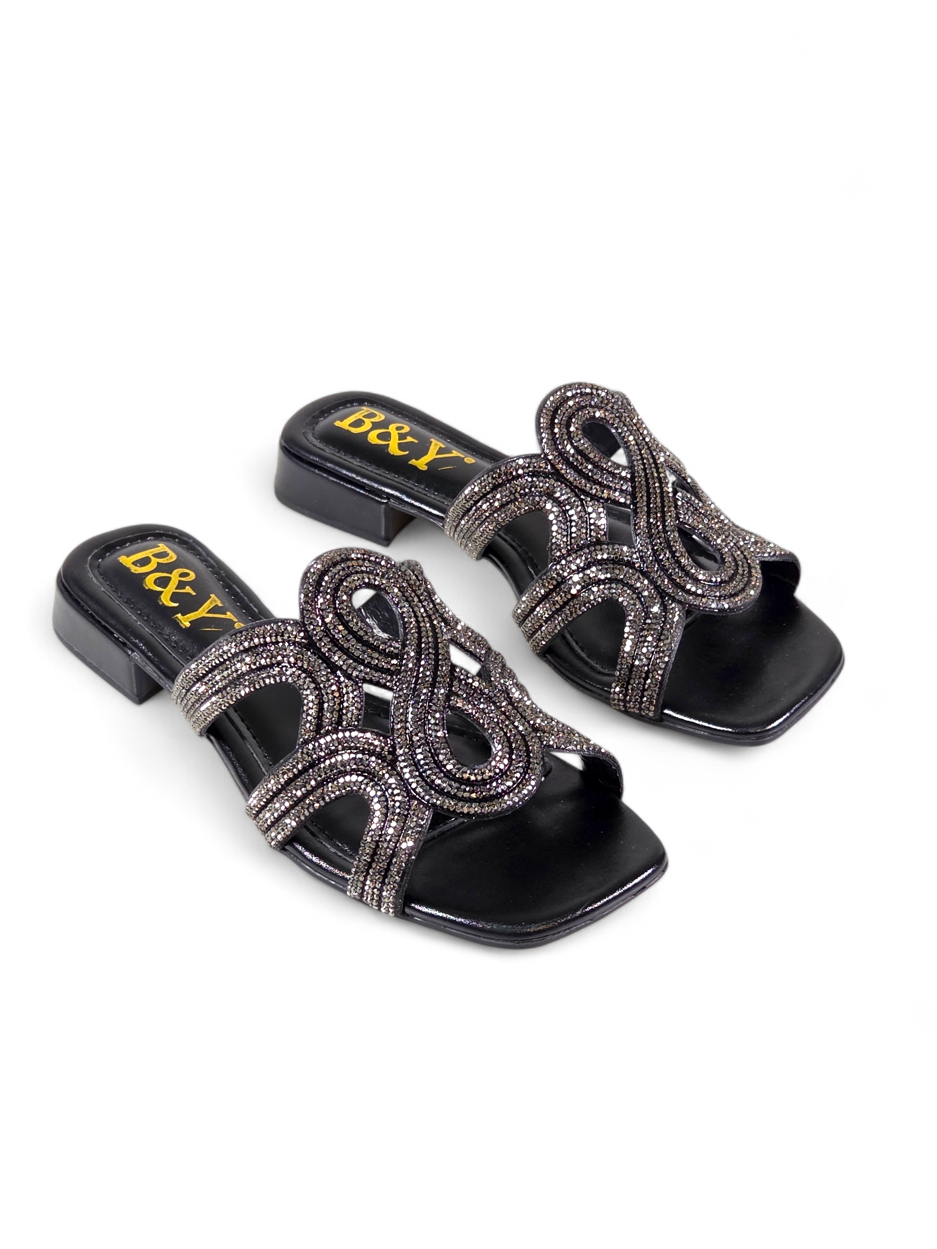 Sandália artesanal B&Y preta com tiras ornamentais cravejadas de cristais, salto baixo e acabamento sofisticado, em fundo branco.