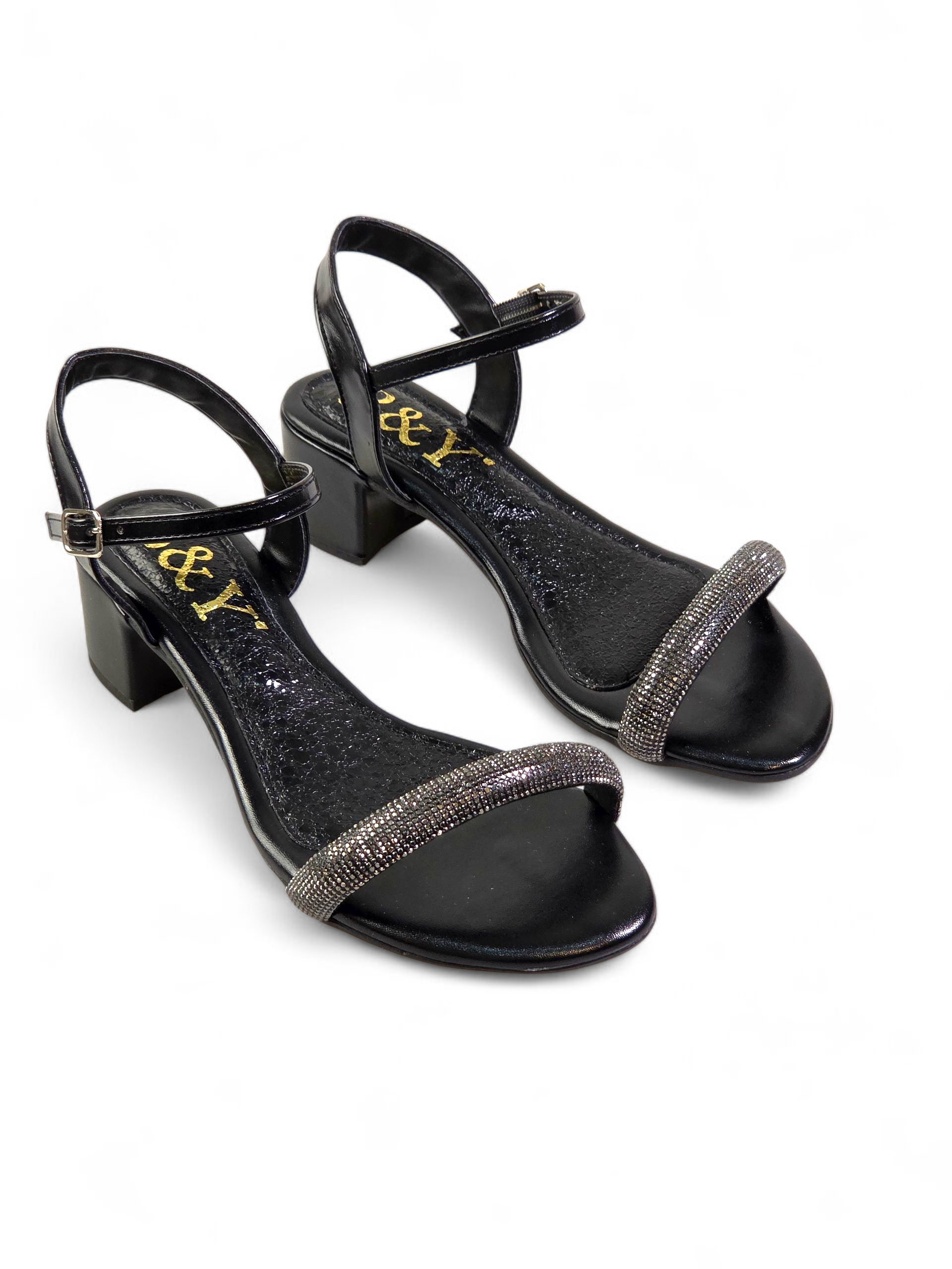 Sandália artesanal feminina preta feita à mão com pedrarias escuras e tiras finas no tornozelo.