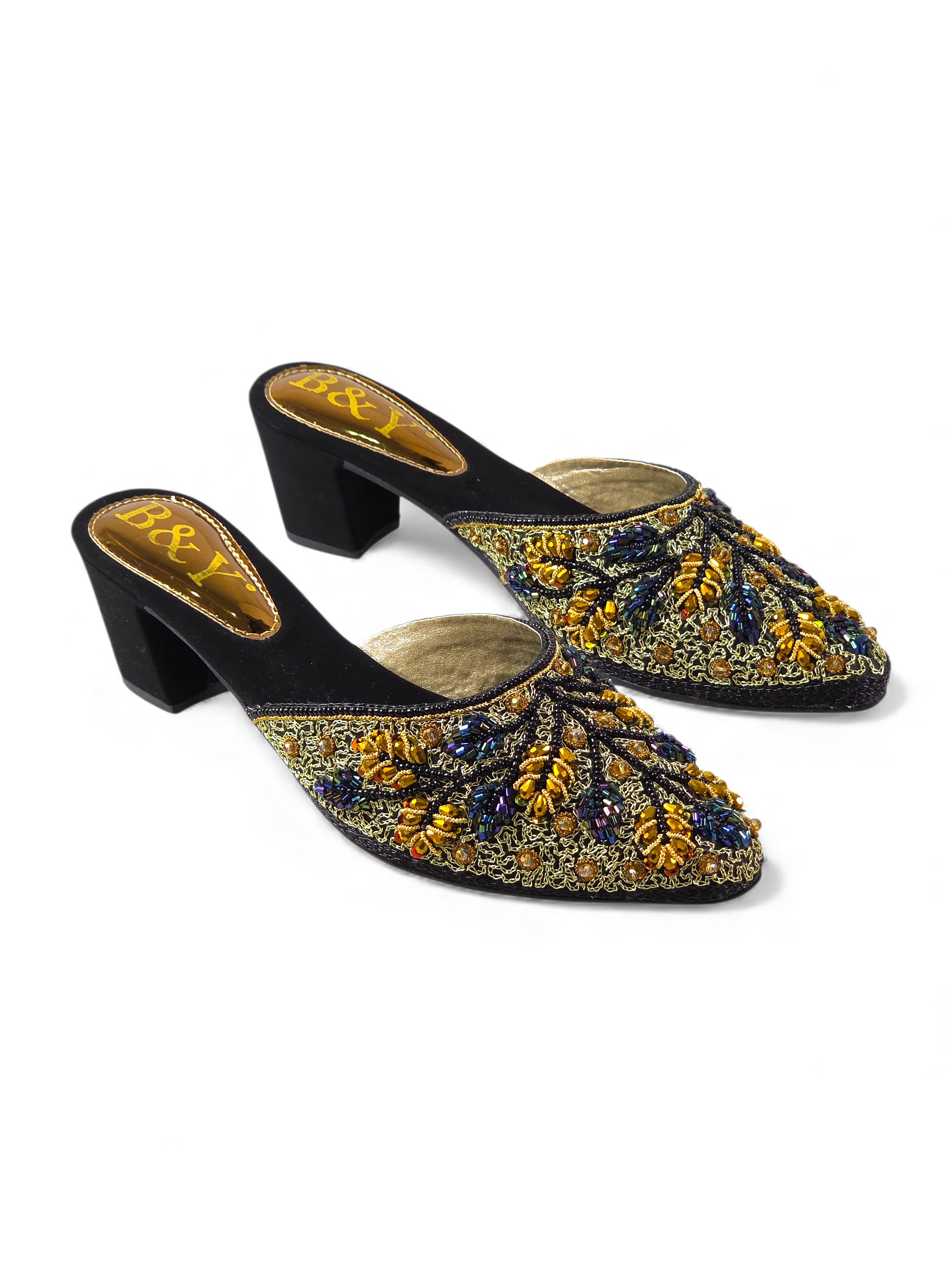 A pair of black and gold embellished mules or heeled sandals with intricate floral designs.